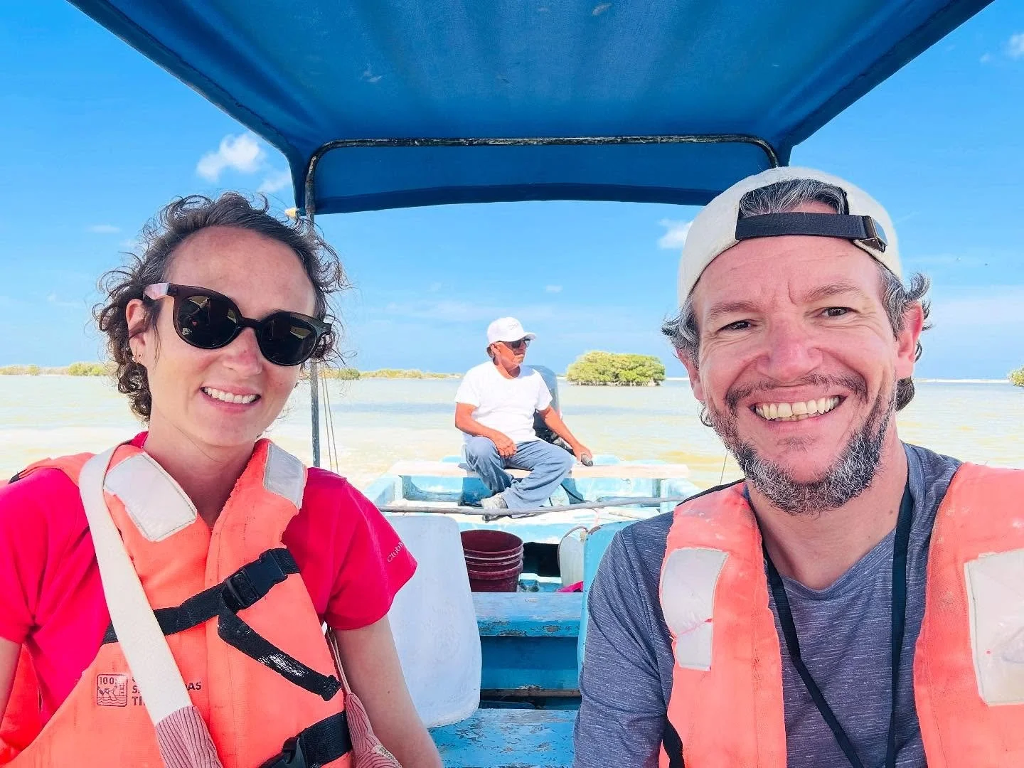Nos deux voyageurs heureux prennent un selfie sur un bateau lors d'une excursion en mer, avec le capitaine mexicain en arrière-plan.