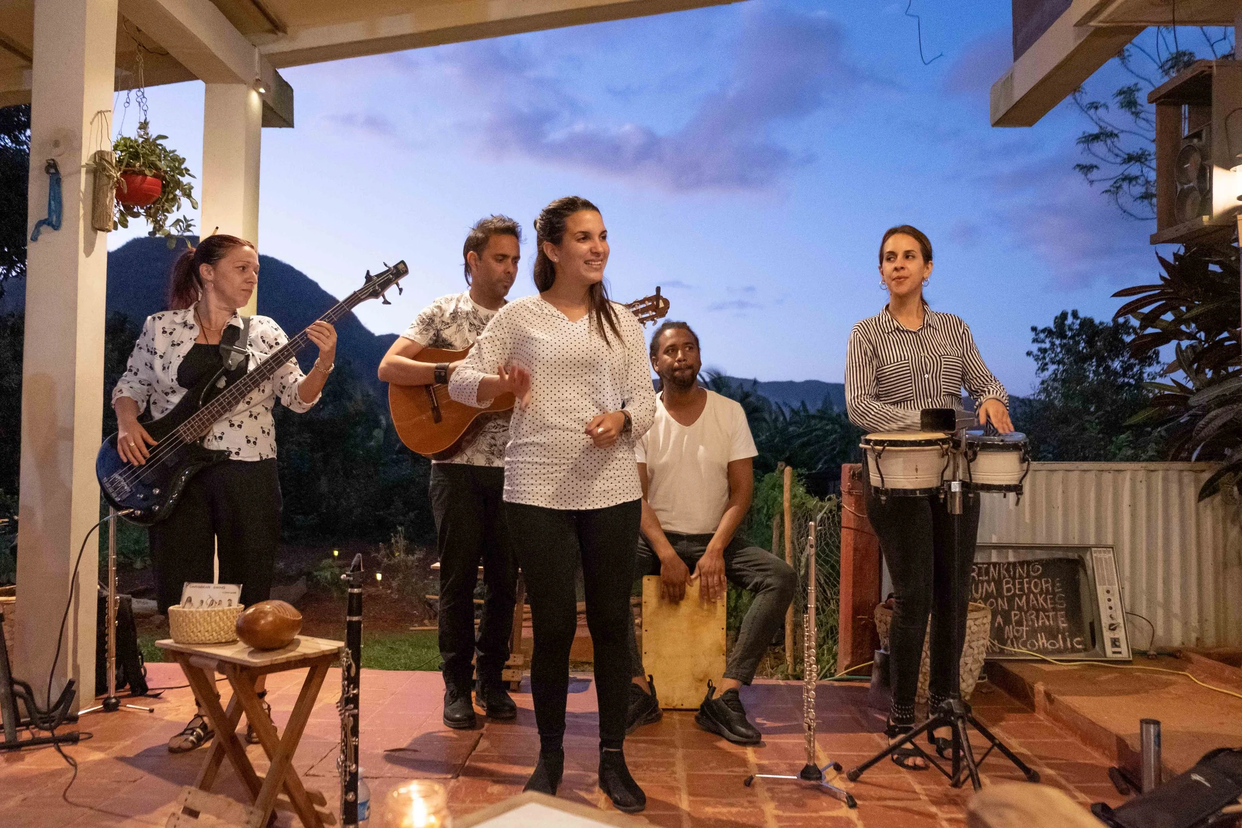 Groupe de musiciens et chanteurs performants lors d'un concert en plein air au crépuscule, à Cuba.