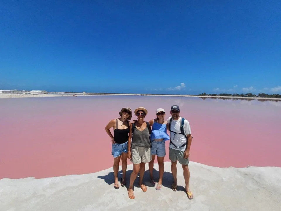 Notre famille de voyageurs pose devant la Laguna Rosada au Mexique, sous un magnifique ciel bleu.