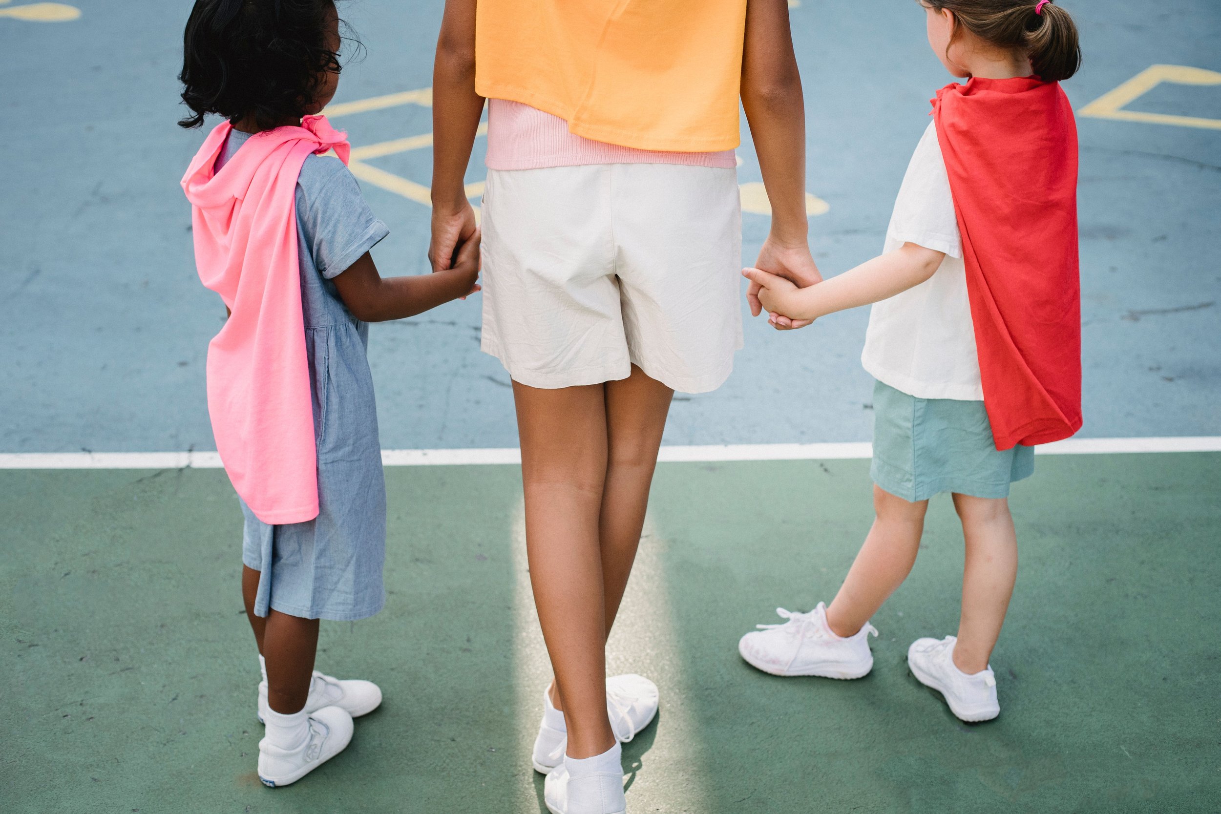 adult and two children holding hands before exercising