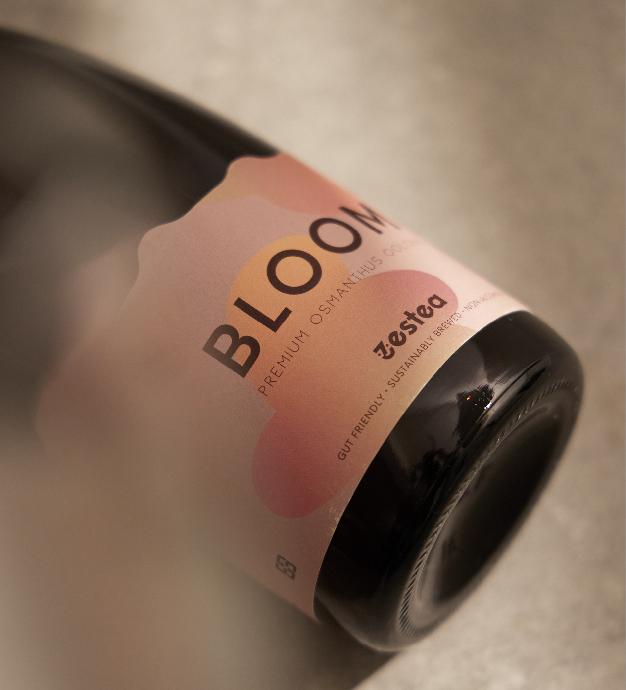 A dark bottle with a pink label that reads 'BLOCK' and features a peach illustration, labeled as 'Premium Osmanthus Oolong' and 'ZeStea,' emphasizing gut-friendly, sustainable brewing.