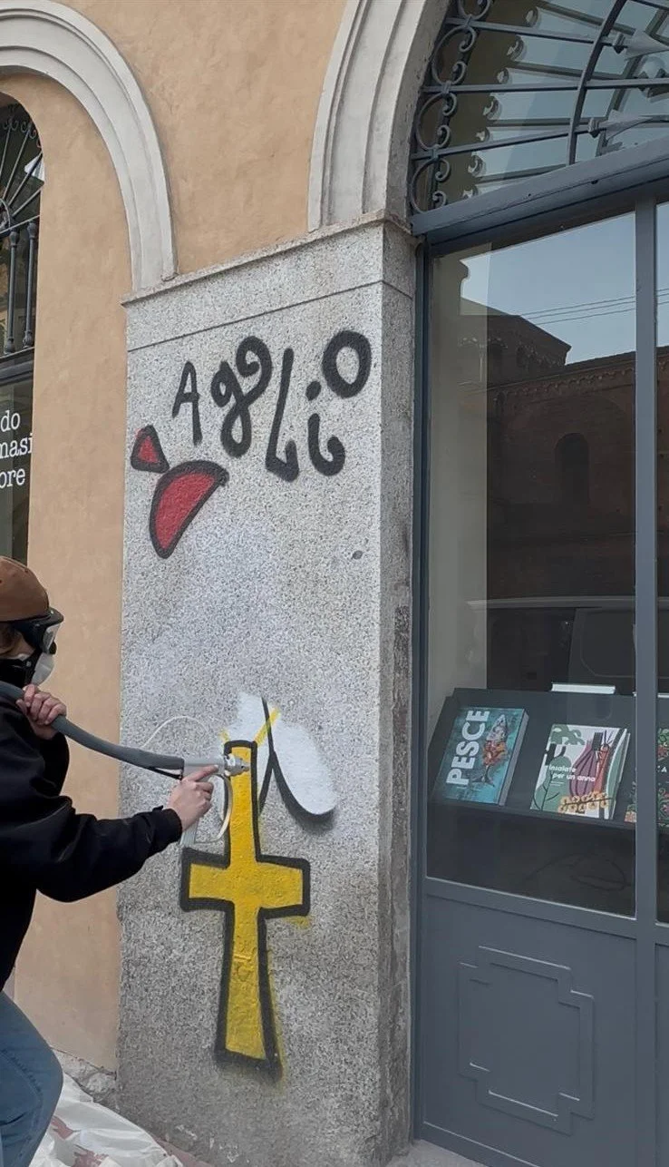 Persona con che pulisce il muro da un graffito con sabbiatrice professionale
