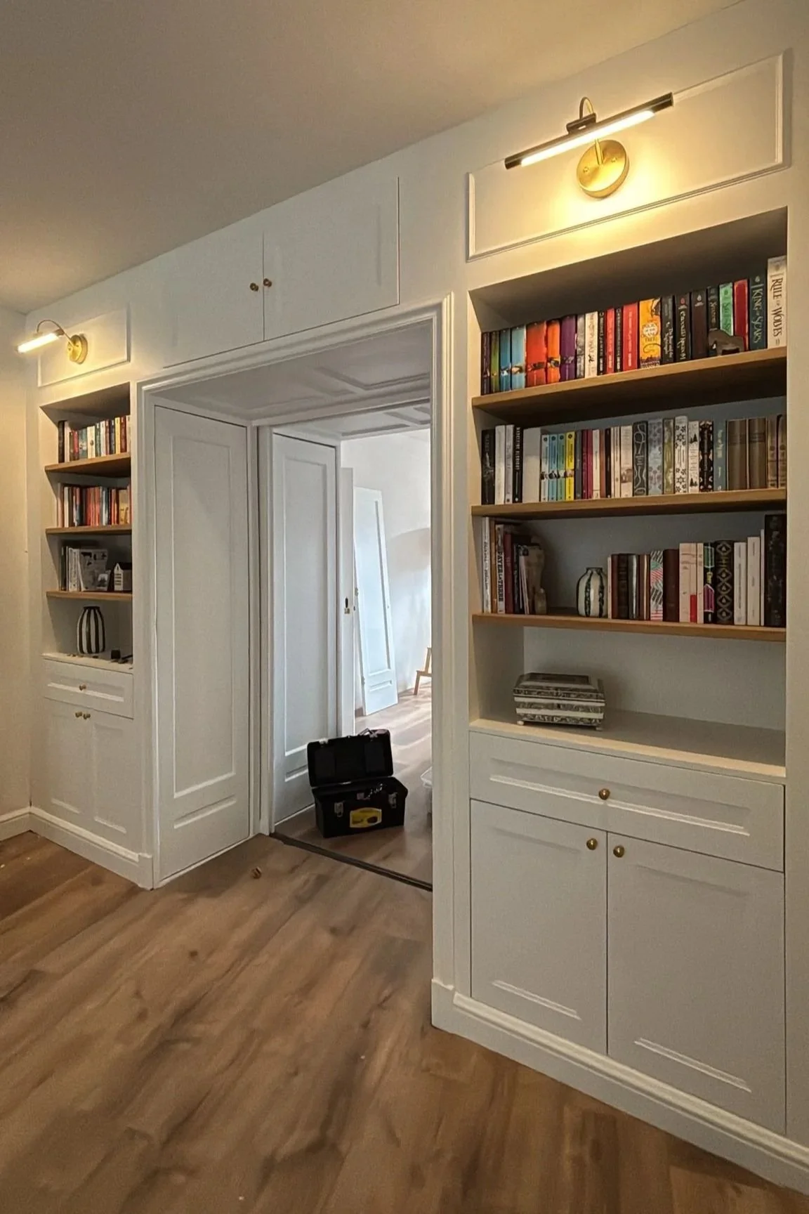 Art deco restoration and renovation -  built-in antique 1930s room divider with bookshelves, gallery lights, wall trim, sliding doors, and stain glass. 