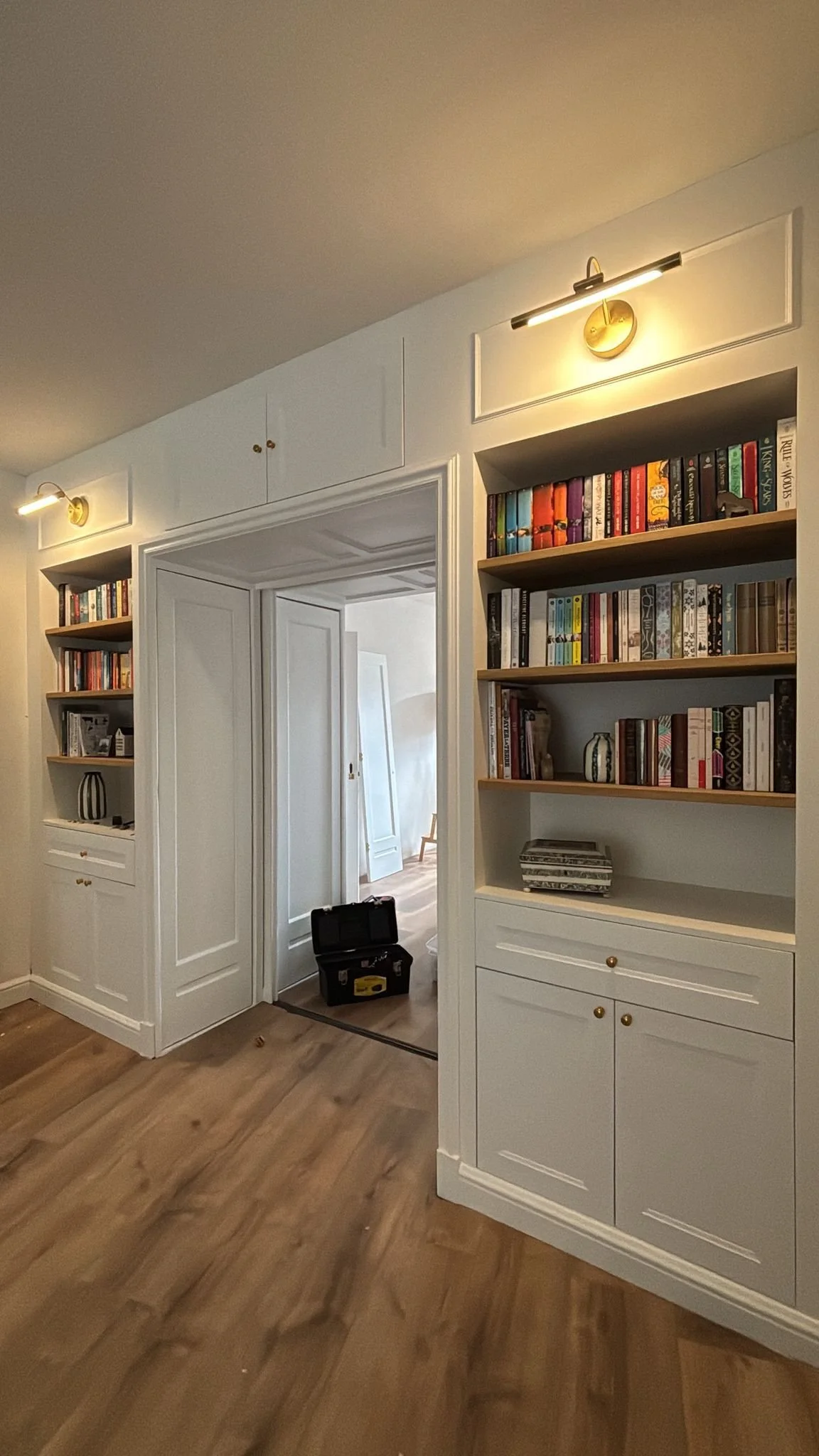 Art deco restoration and renovation -  built-in antique 1930s room divider with bookshelves, gallery lights, wall trim, sliding doors, and stain glass.