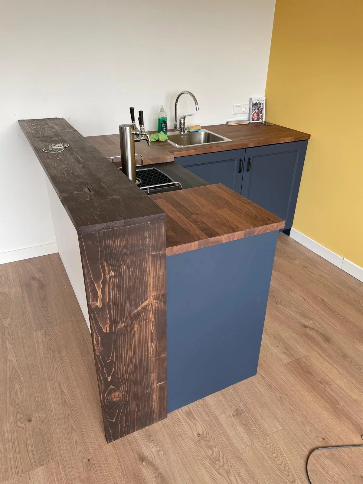 Home bar build with blue cupboards and butcher block counter tops. Beer taps and kitchenette built in.