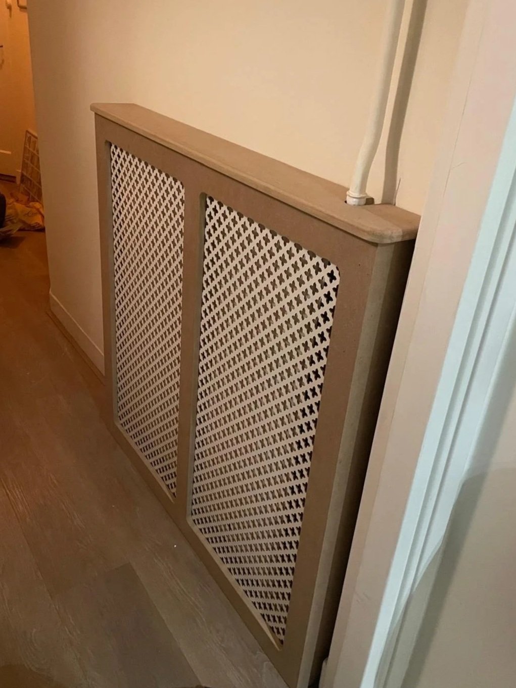 Custom radiator covering with lattice and MDF construction.