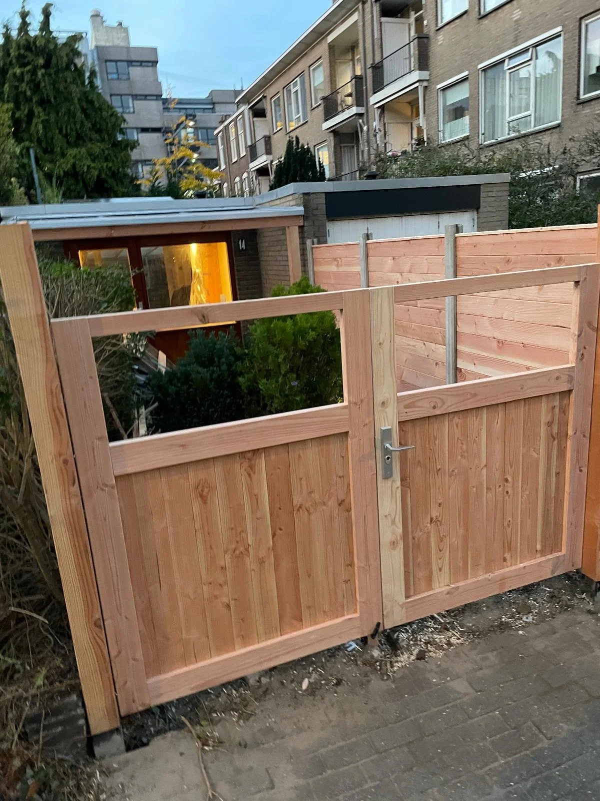 Driveway or garden double gate made of timber with a latch and lock. Garden fence.