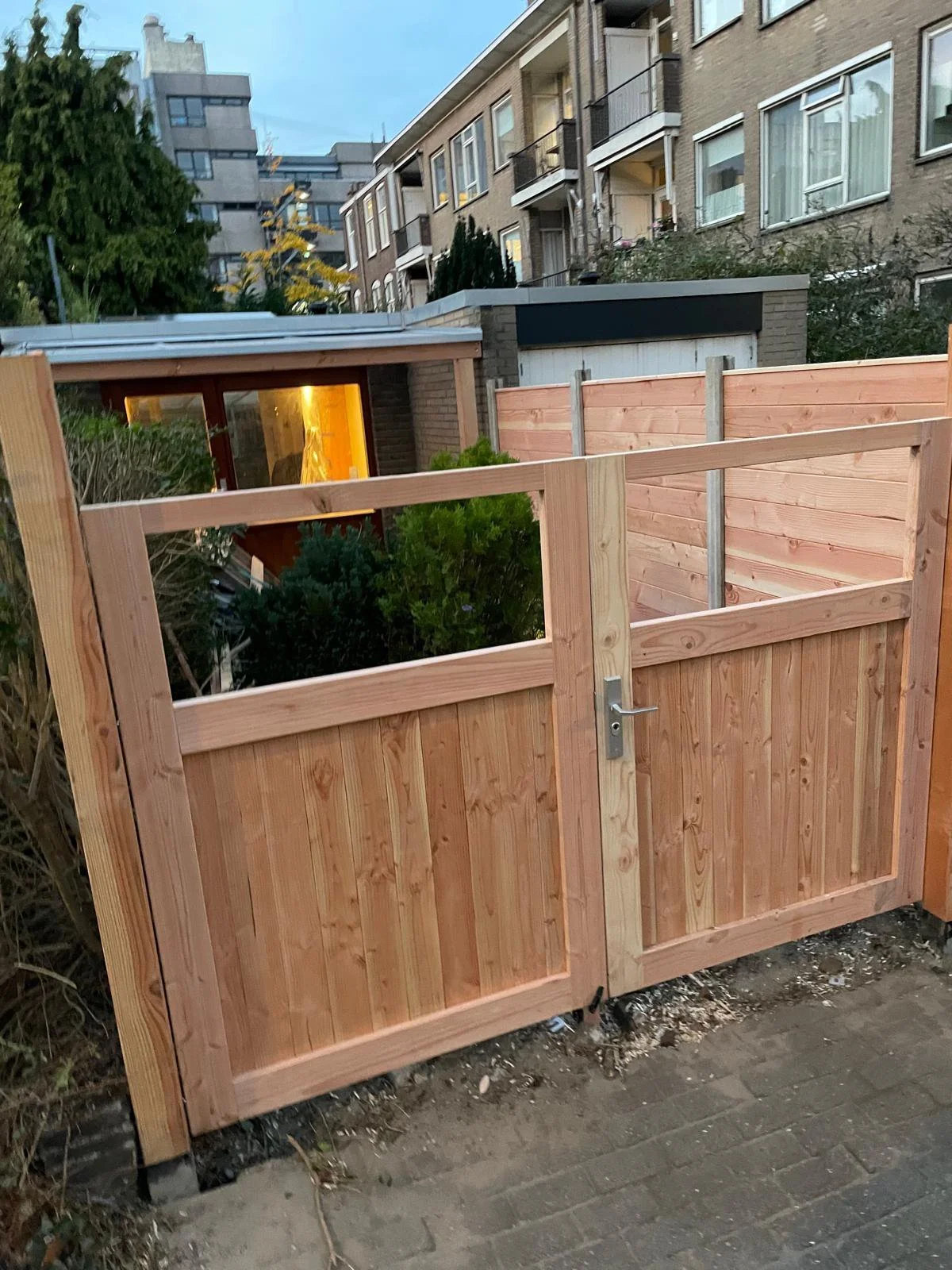 Driveway or garden double gate made of timber with a latch and lock. Garden fence.