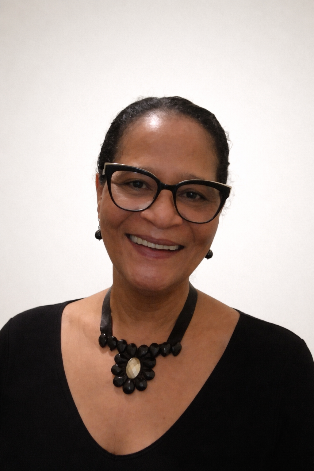 Mulher sorridente usando óculos escuros e brincos em ambiente interno