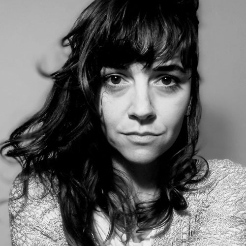 Retrato de uma mulher com cabelo encaracolado e ajeitado, olhando para a câmera, em escala de cinza.