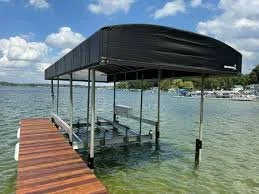 Pier with a boat dock extending into a body of water, with a covered boat shelter overhead, under a partly cloudy sky.