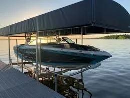 A speedboat docked under a covered boat slip on a lake.