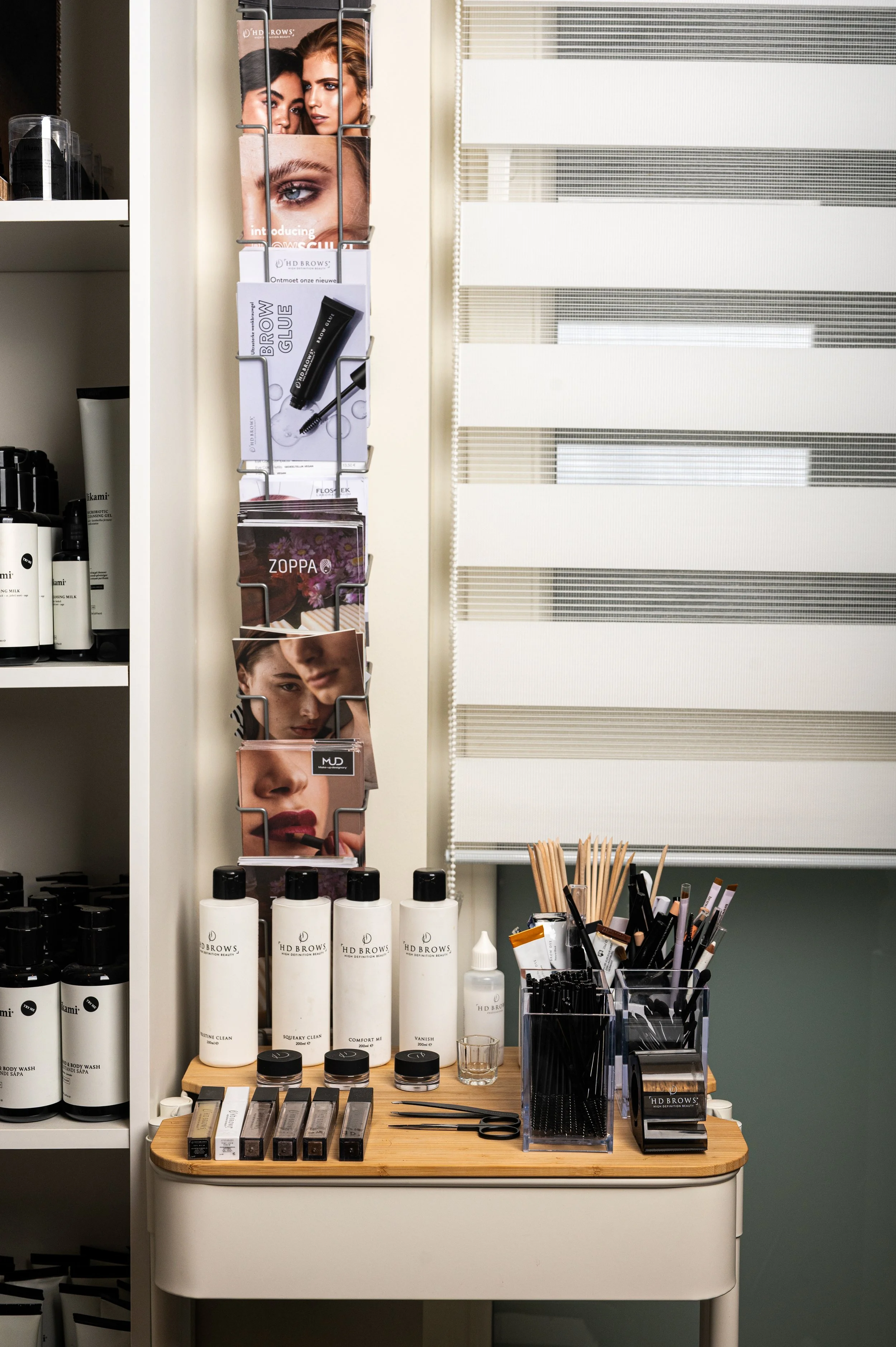 Display of beauty products and tools at a salon or spa, including bottles, containers, magazines, and various cosmetic tools.