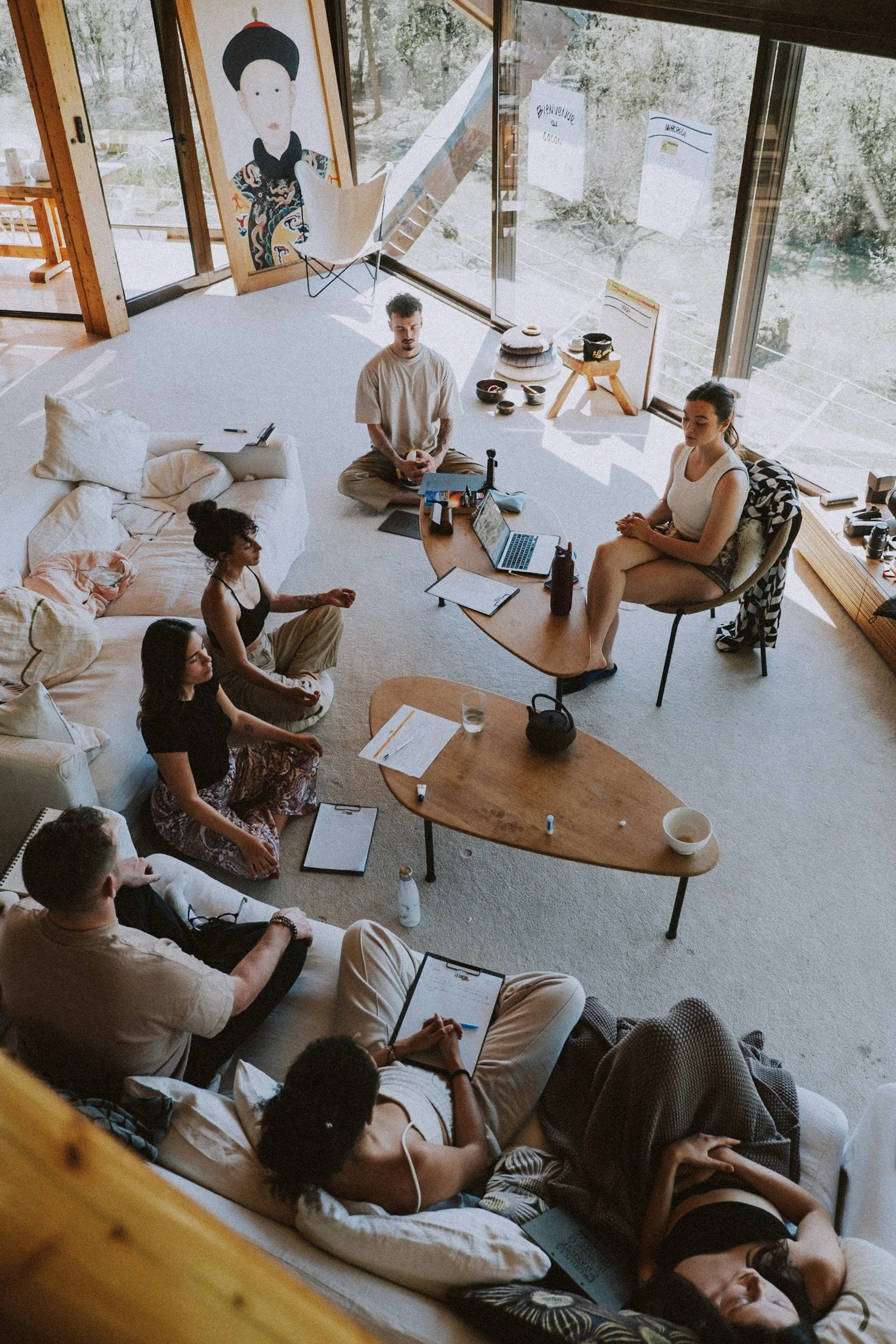 Group of people gathered in a sunlit room, representing group therapy for life transitions at AGC International.