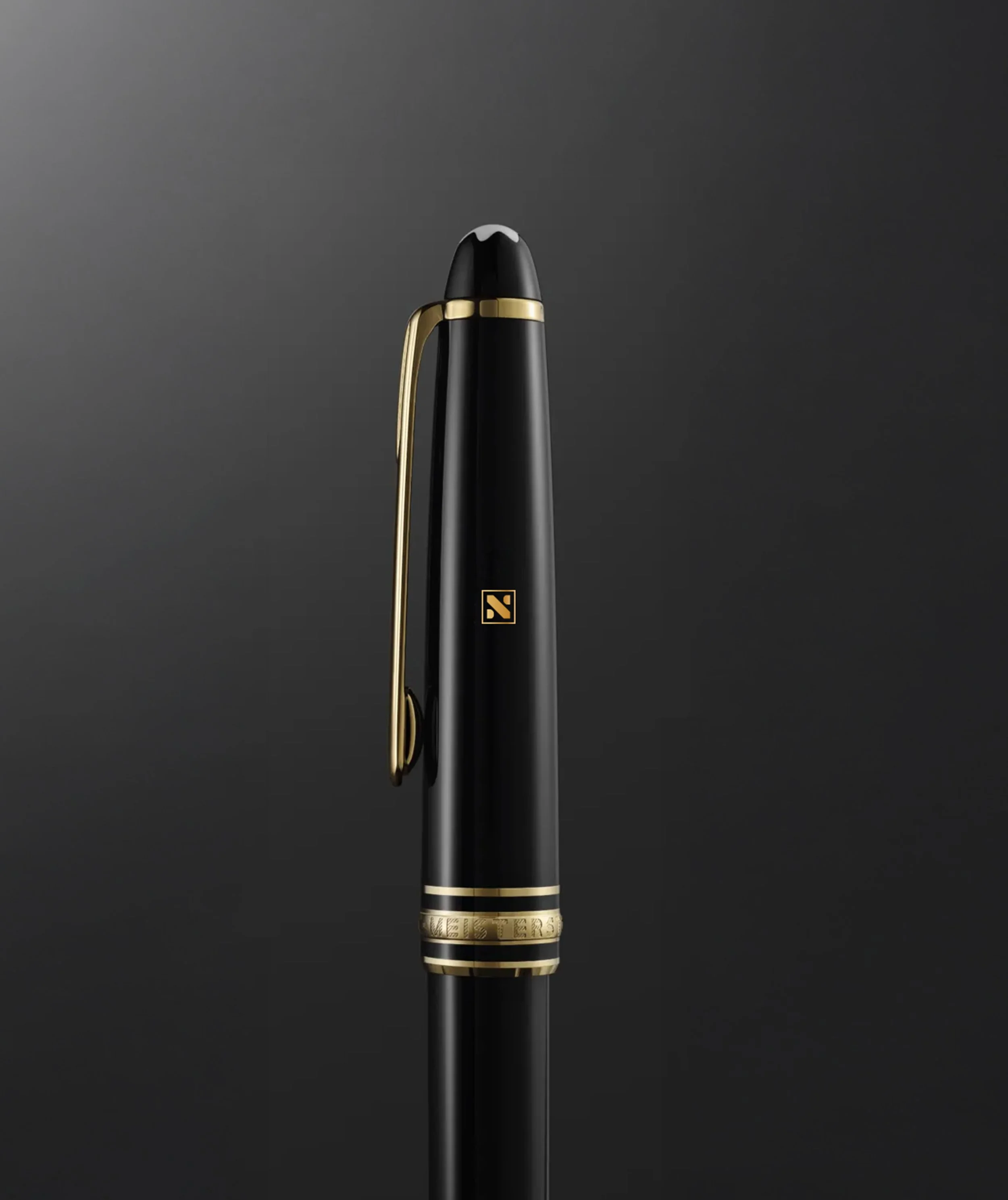 Close-up of a black and gold gaming mouse with a sleek design and cord, on a dark gray surface.