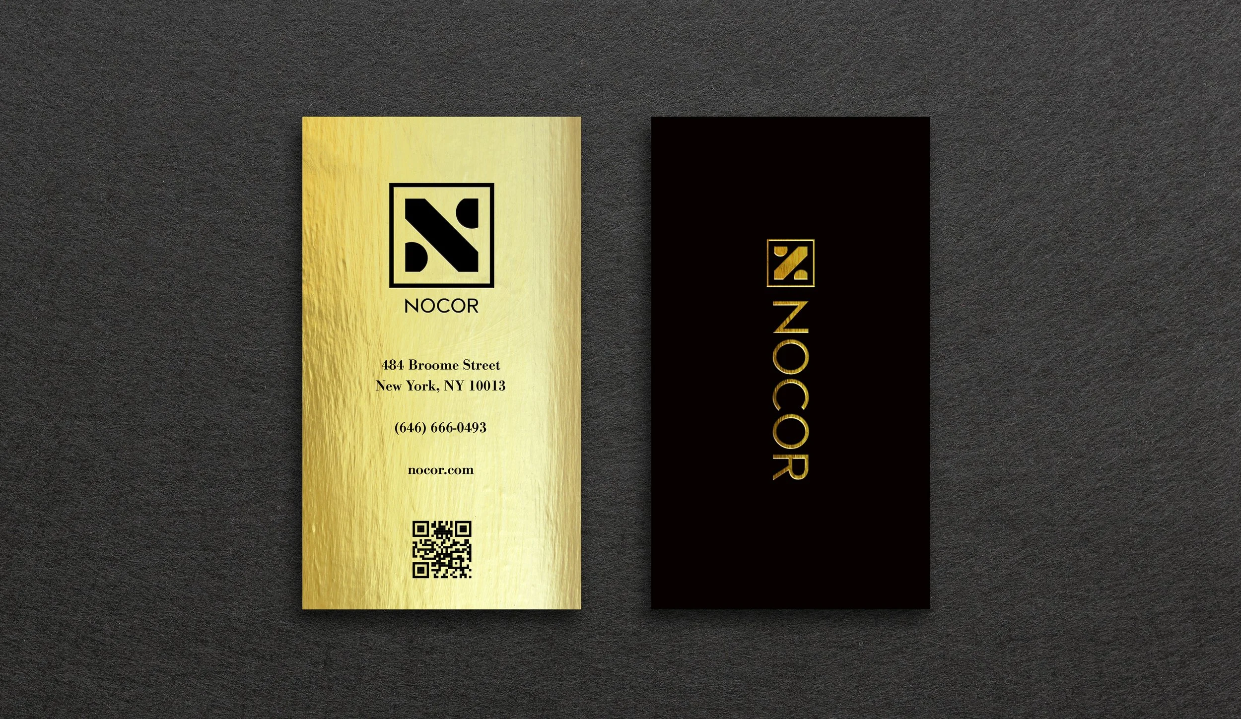 A gold business card with the logo and name 'NOCOR' on it. The card displays an address in New York, NY, a phone number, and a website URL. Next to it is a black card with gold lettering and the same logo.