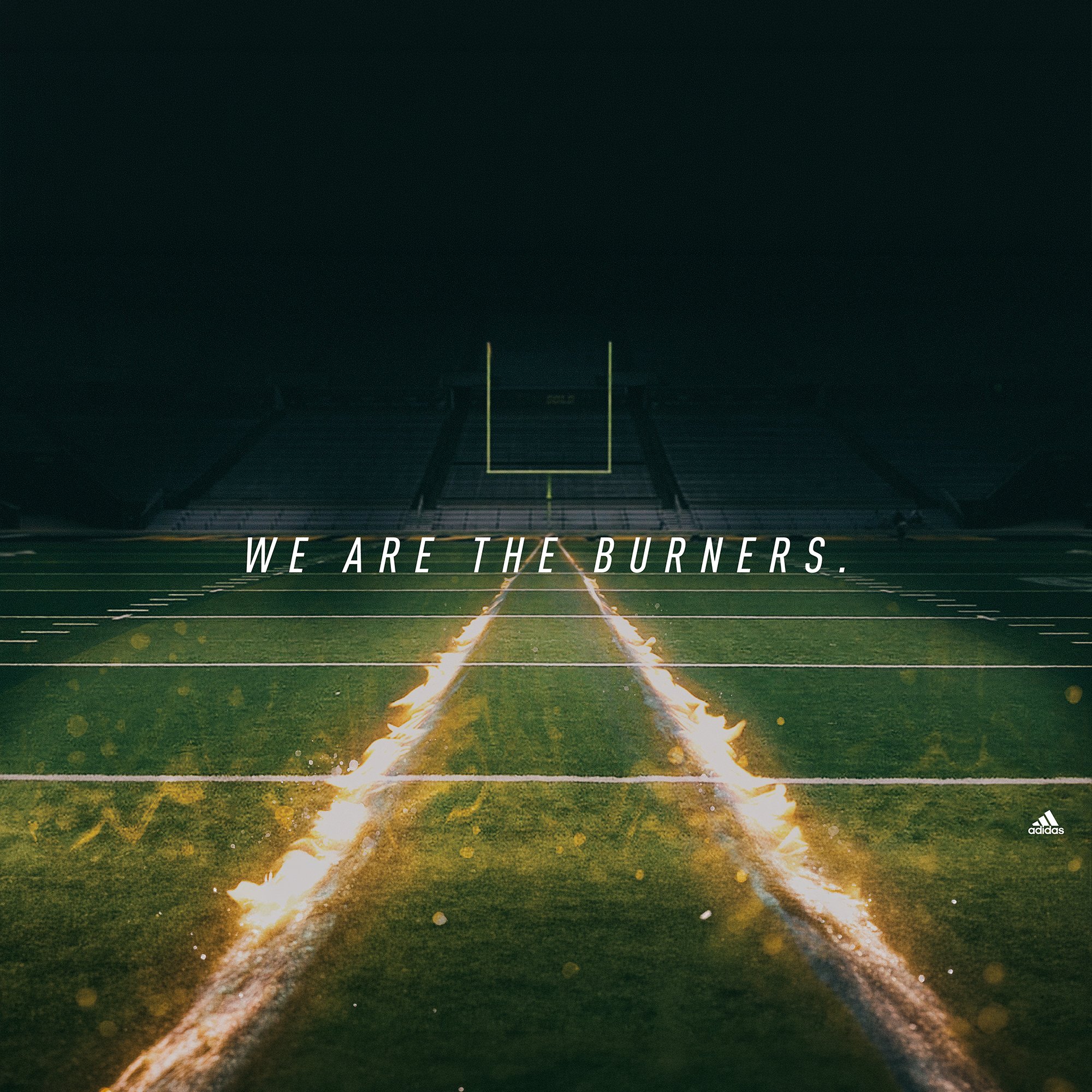 A football field at night with football goal posts and markings, with city lights in the distance and a motivational quote 'We Are the Burners' overlayed.