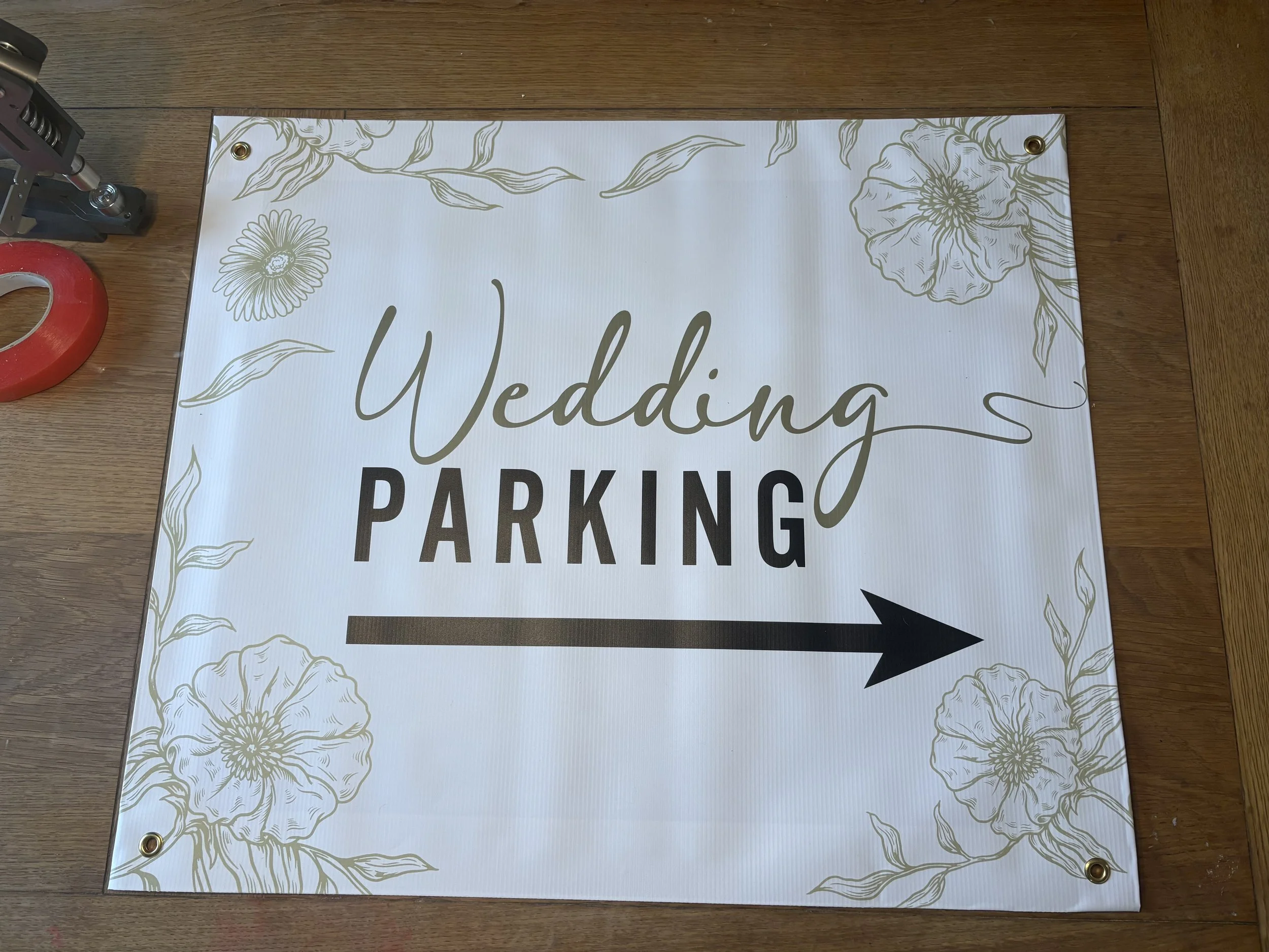 A sign with a floral border and the words 'Wedding Parking' with an arrow pointing to the right.