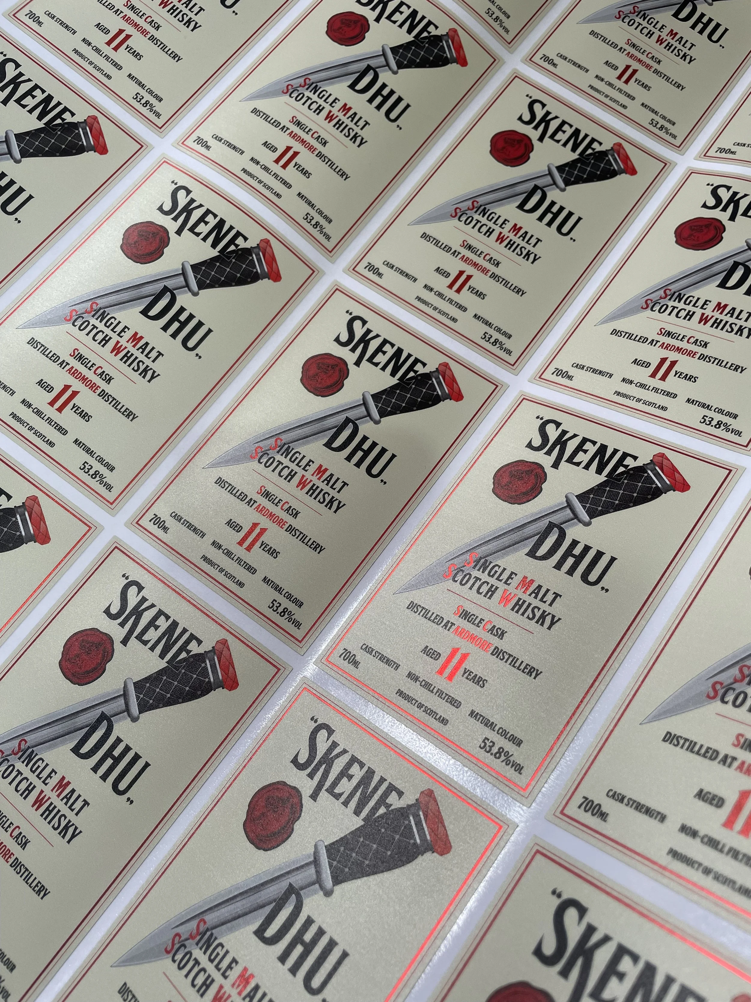 Multiple labels of Skene Whiskey with a logo of a knife and a wax seal.