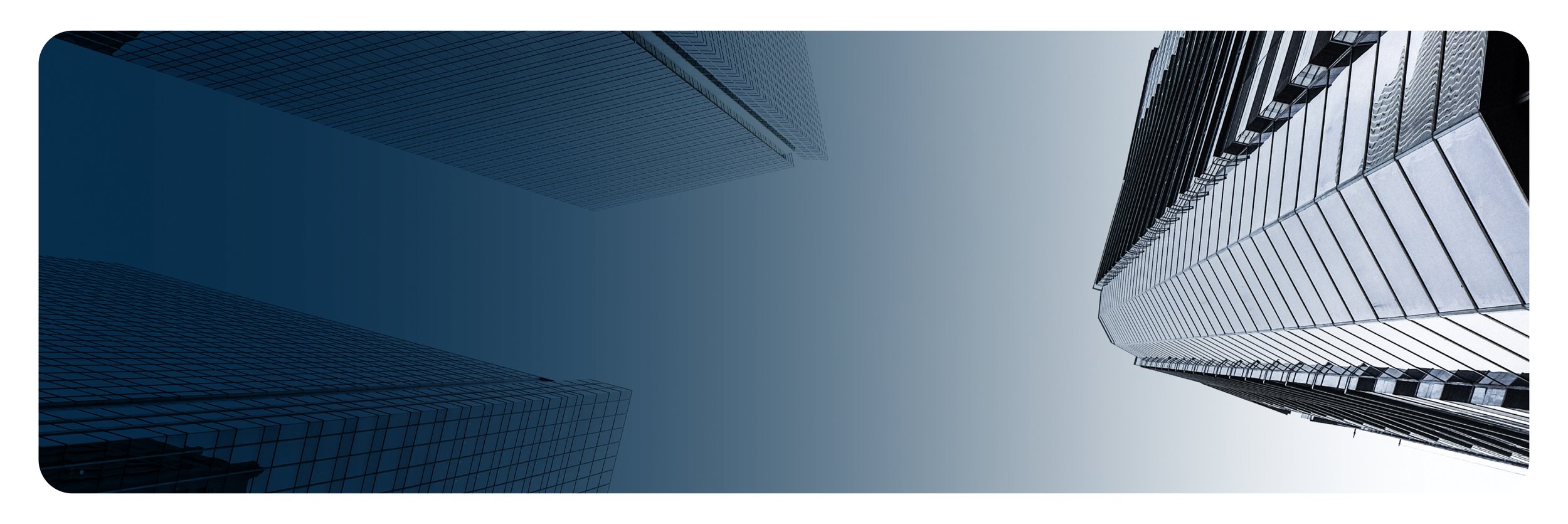 Looking up at three tall modern skyscrapers with reflective glass windows against a gray sky.