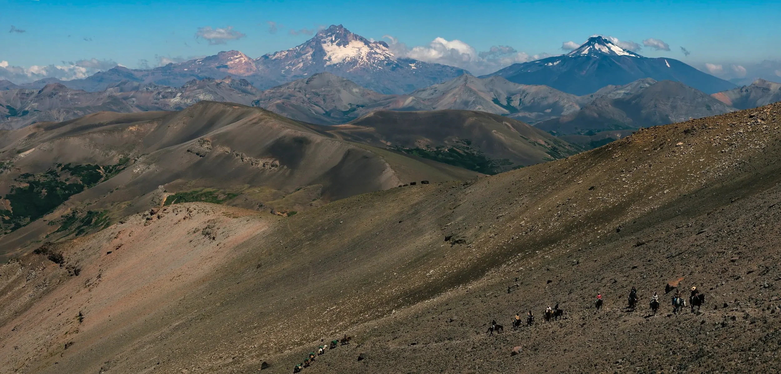 Riders and pack horses crossing a steep mountain pass in northern Patagonia, Argentina