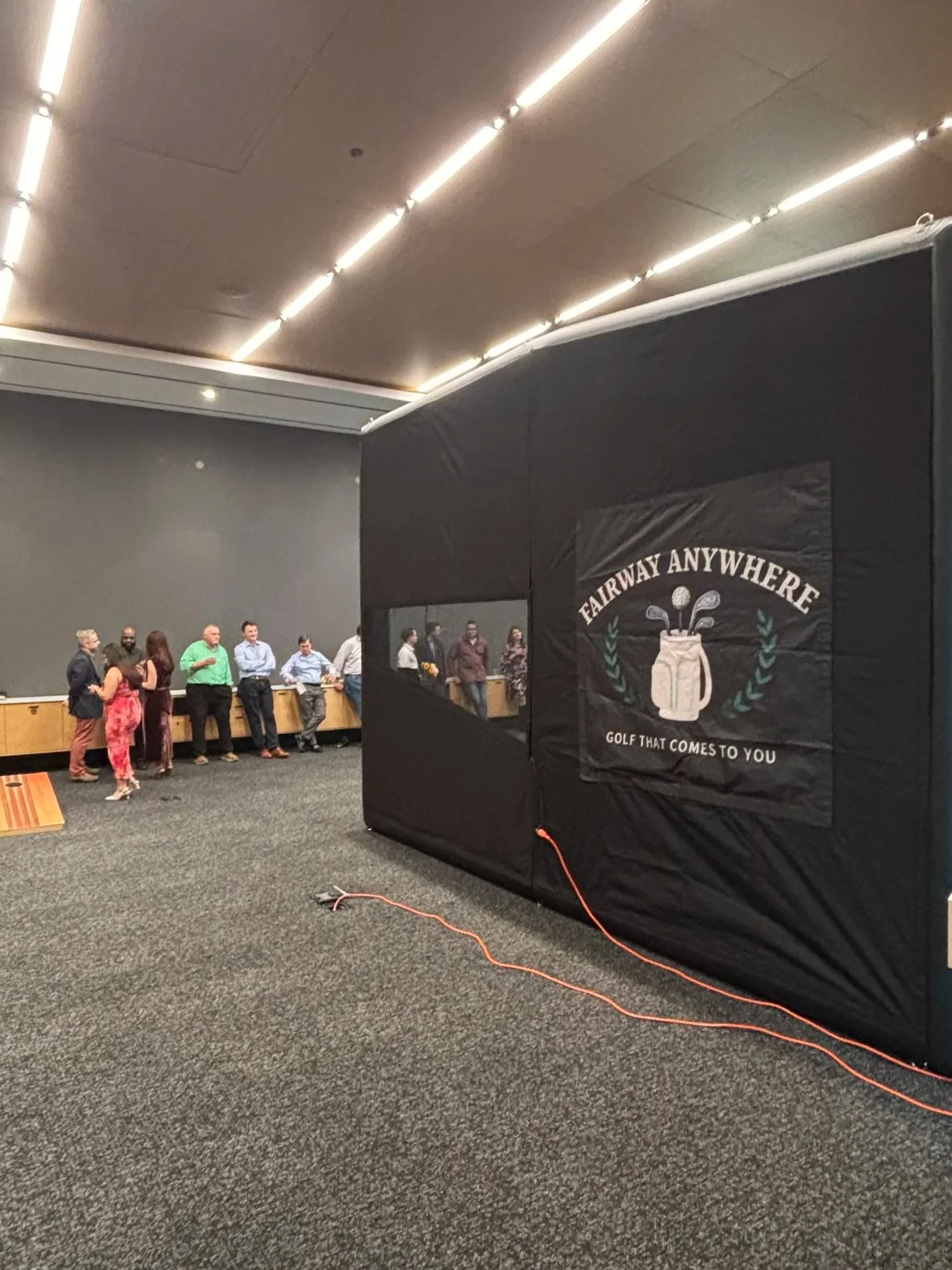 employees using golf simulator at corporate event