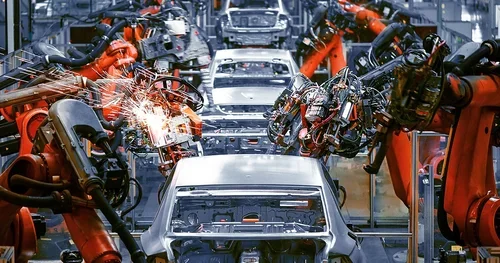 Robotic arms assemble cars on an automotive production line.