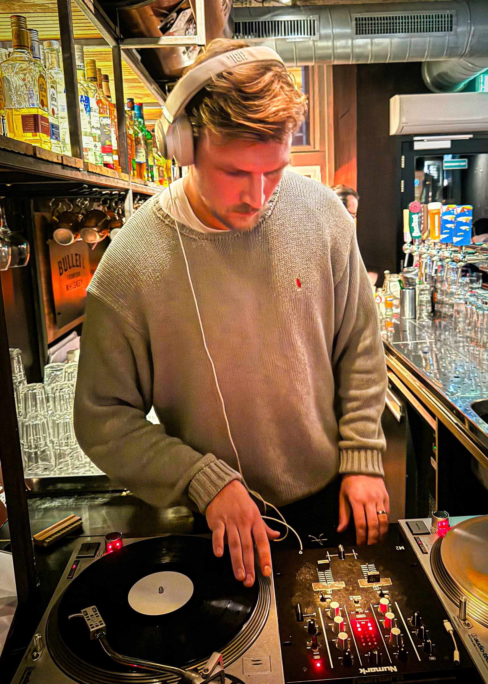 farmer (Juri) at the turntables playing a guest DJ set at Amsterdam Vinyl Club, a live music community event.