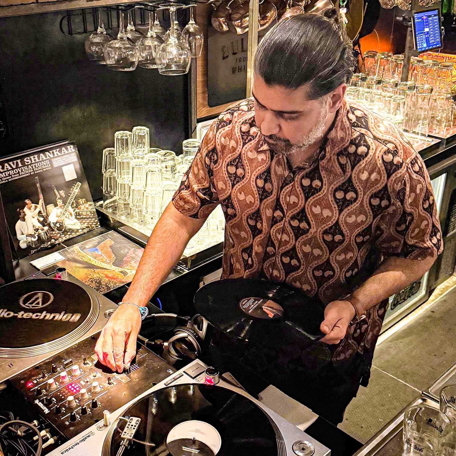 Deepak Nichani at the turntables playing a guest DJ set at Amsterdam Vinyl Club, a live music community event.