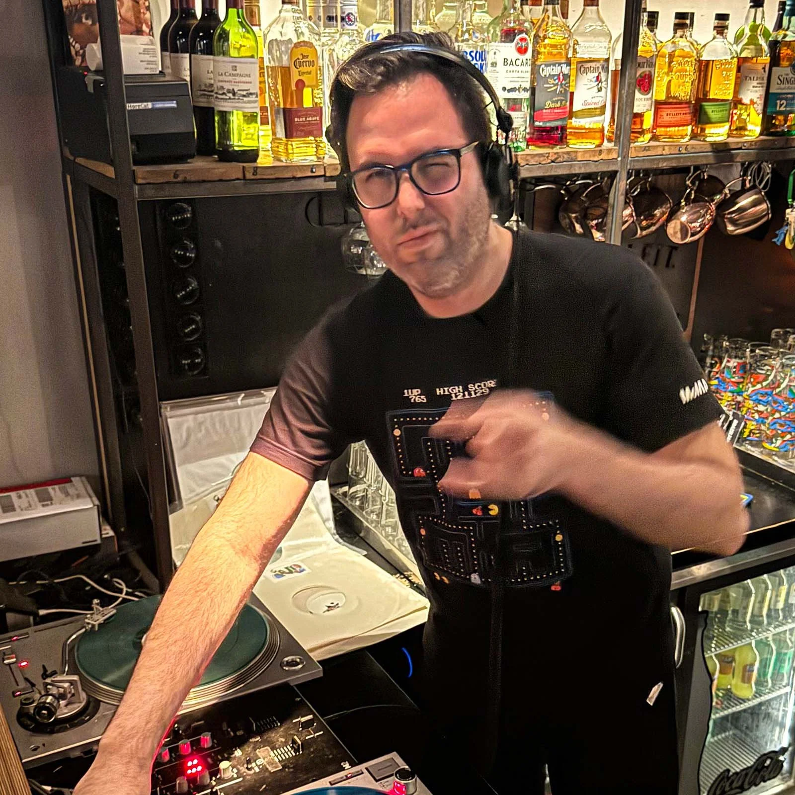 DJ Ermac at the turntables playing a guest DJ set at Amsterdam Vinyl Club, a live music community event.
