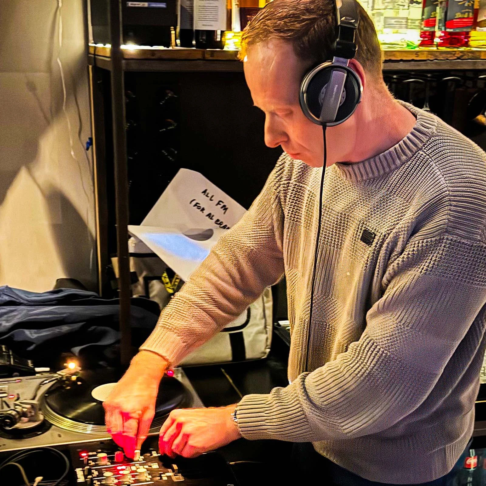 DJ Miro at the turntables playing a guest DJ set at Amsterdam Vinyl Club, a live music community event.
