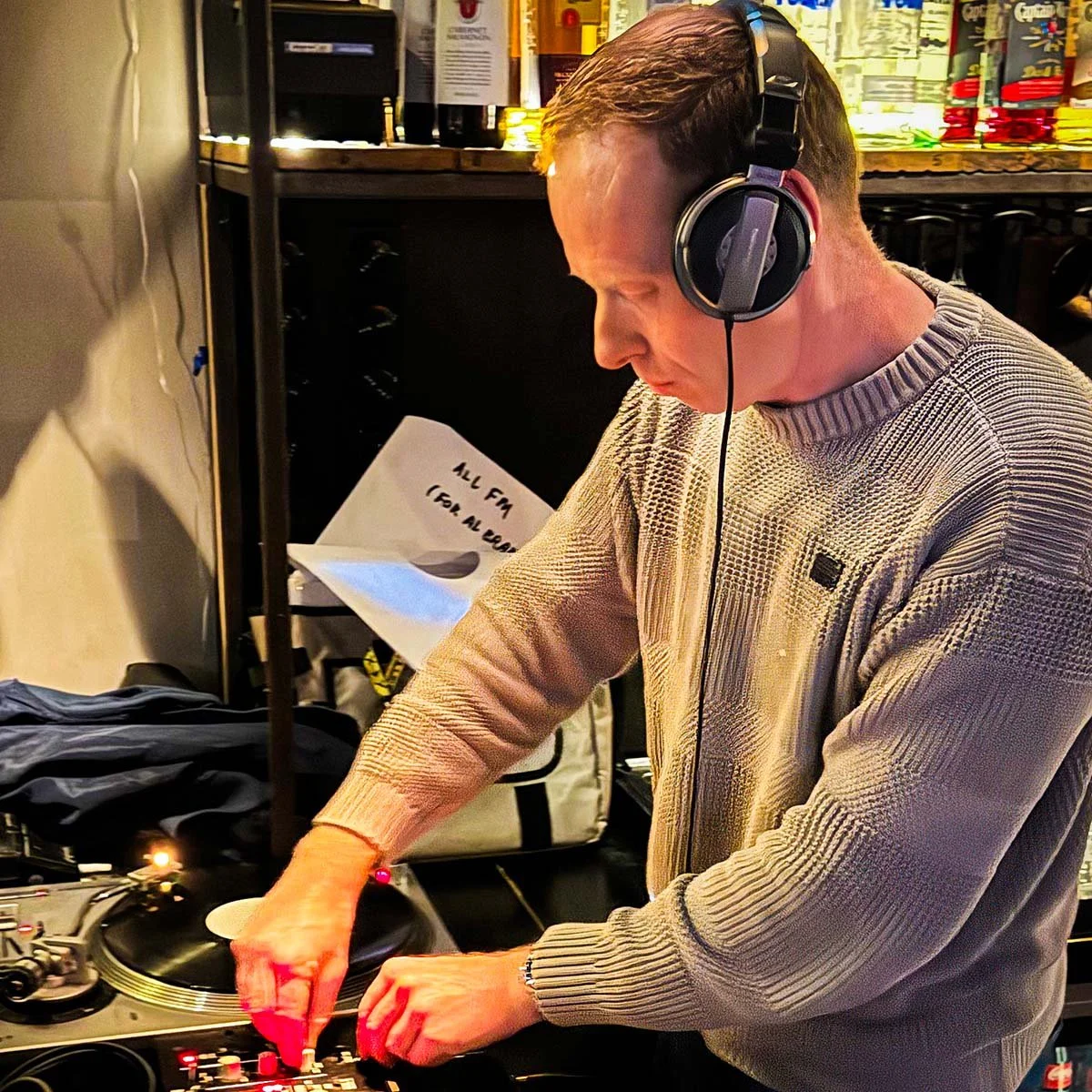 DJ Miro at the turntables playing a guest DJ set at Amsterdam Vinyl Club, a live music community event.