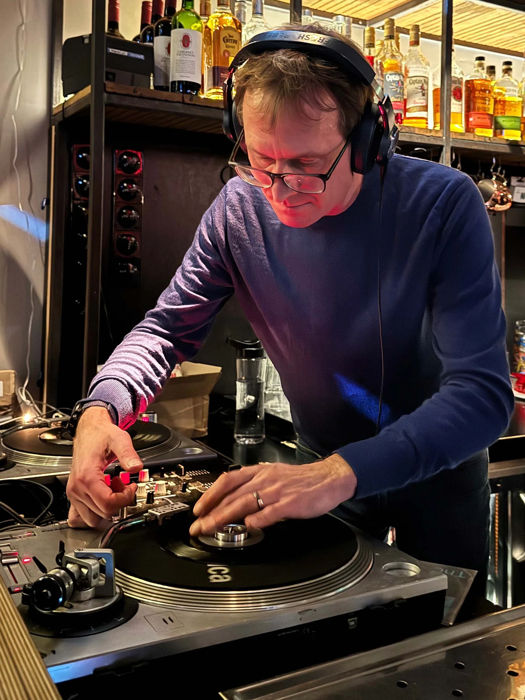 DJ Multimuck at the turntables playing a guest DJ set at Amsterdam Vinyl Club, a live music community event.
