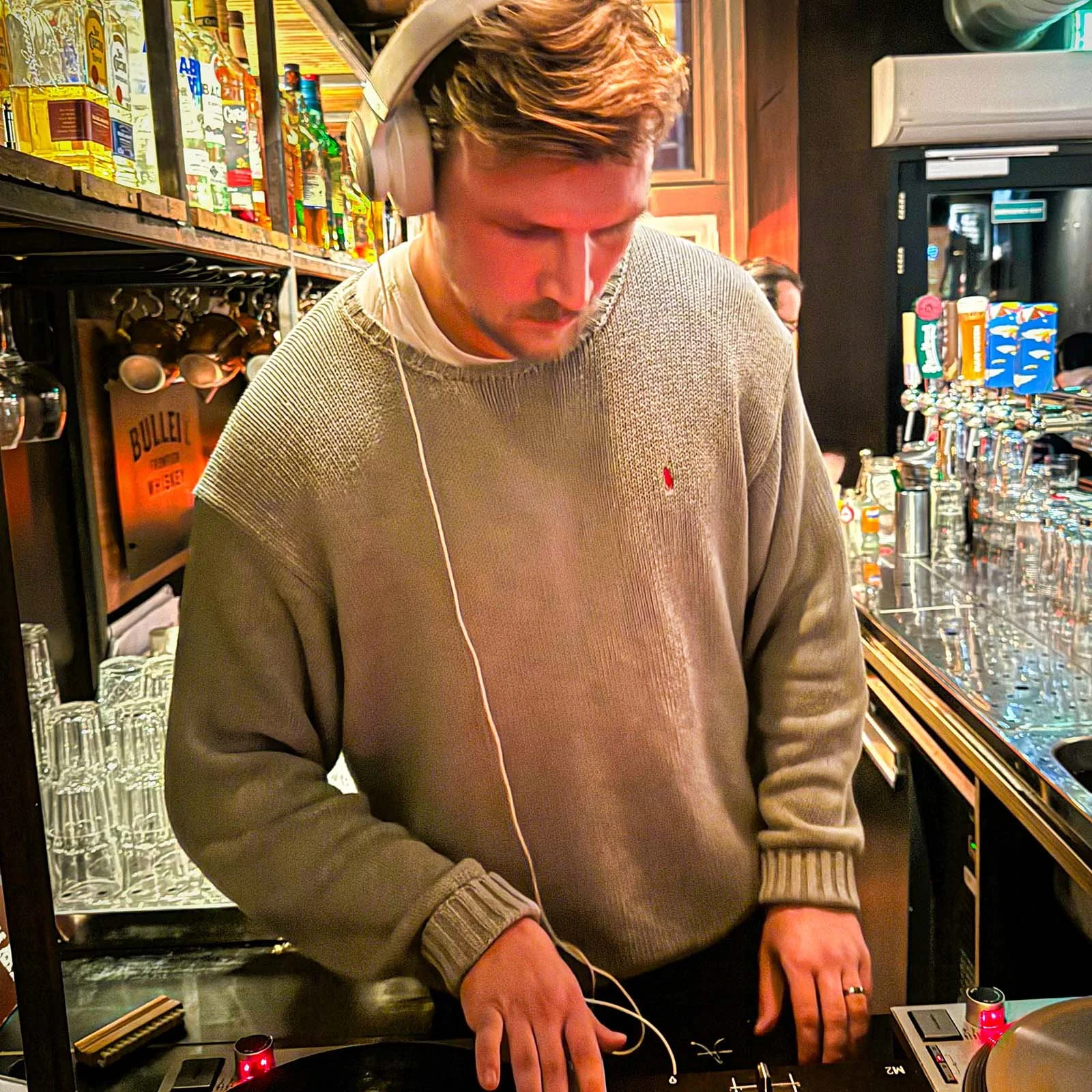 farmer (Juri) at the turntables playing a guest DJ set at Amsterdam Vinyl Club, a live music community event.
