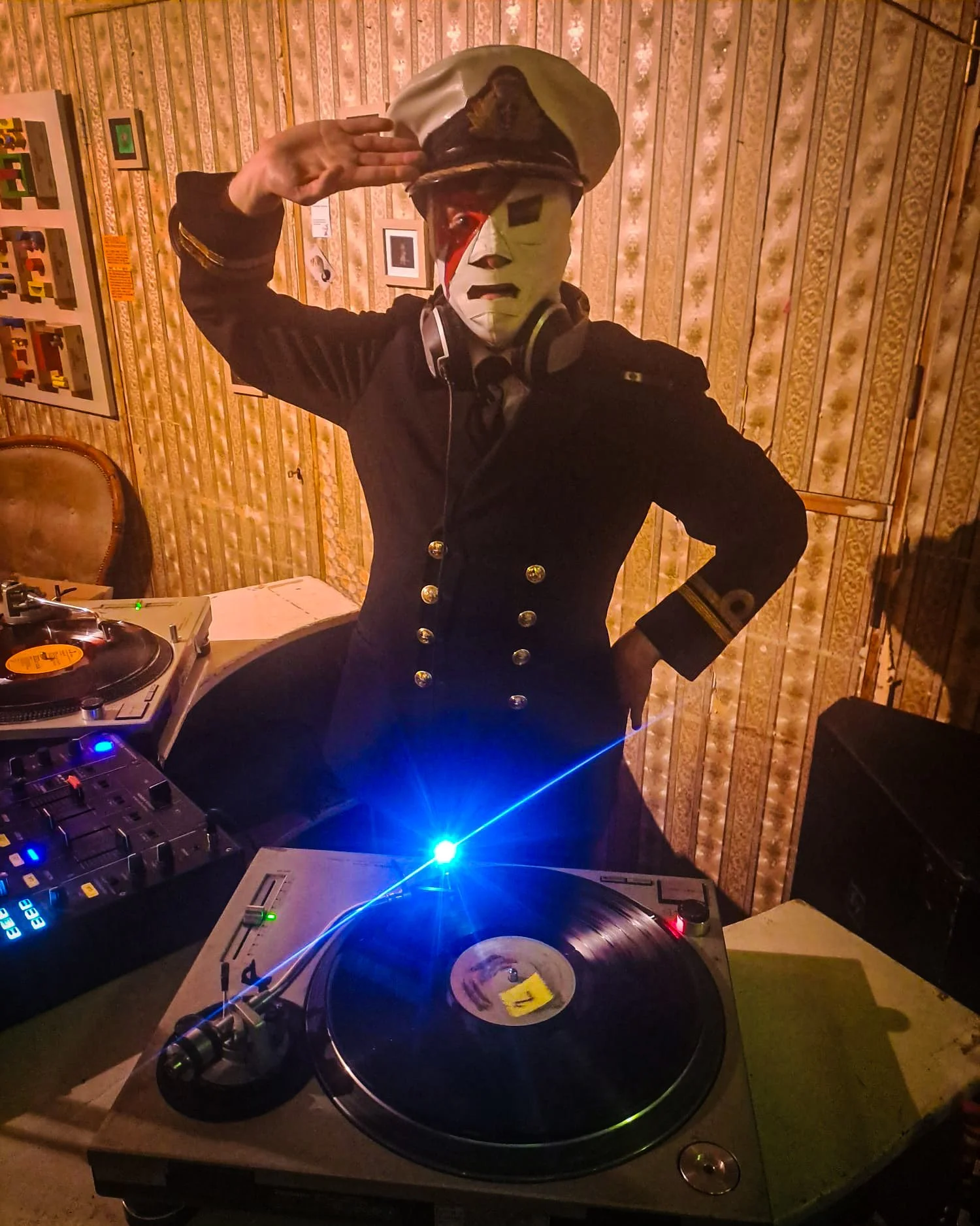 Dr Blackthorn playing a guest DJ set at Amsterdam Vinyl Club. He's wearing a Mexican wrestling mask with a David Bowie Ziggy Stardust lightning flash, and a full naval captain's uniform.