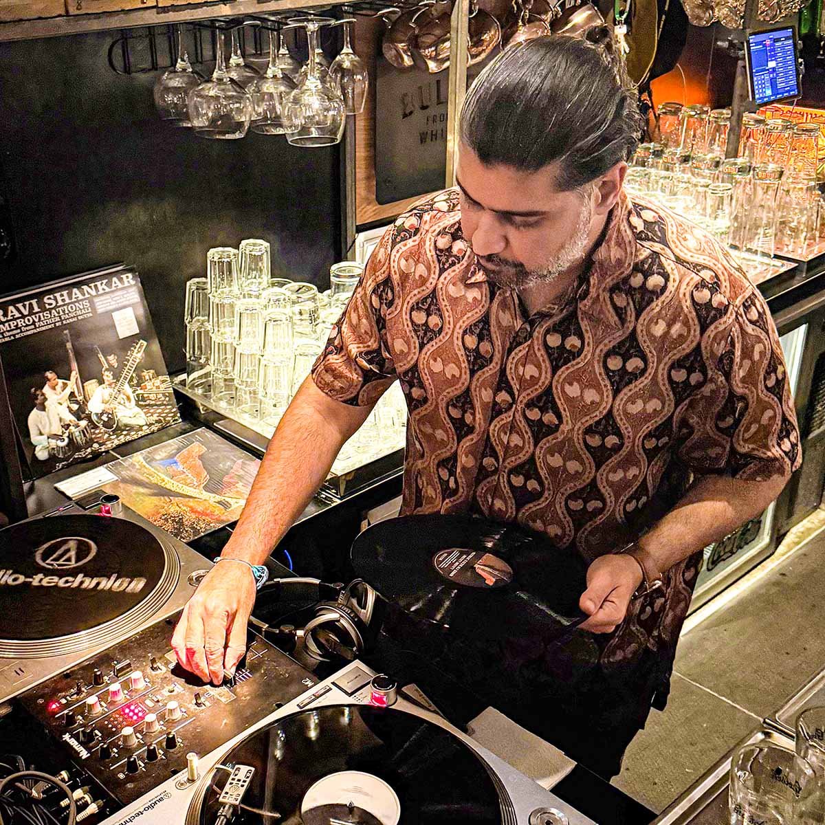 Deepak Nichani at the turntables playing a guest DJ set at Amsterdam Vinyl Club, a live music community event.