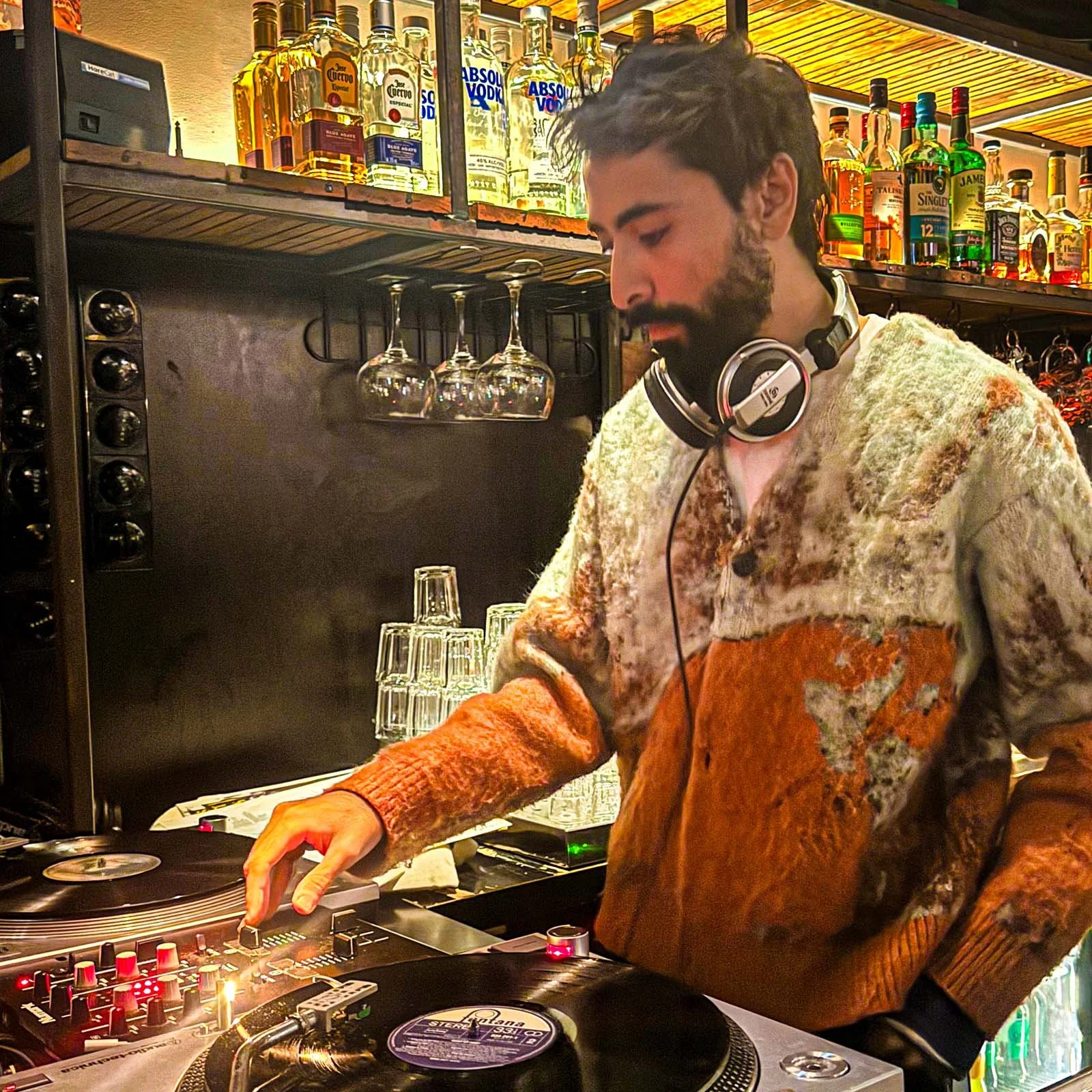 Adnan Samman at the turntables playing a guest DJ set at Amsterdam Vinyl Club, a live music community event.
