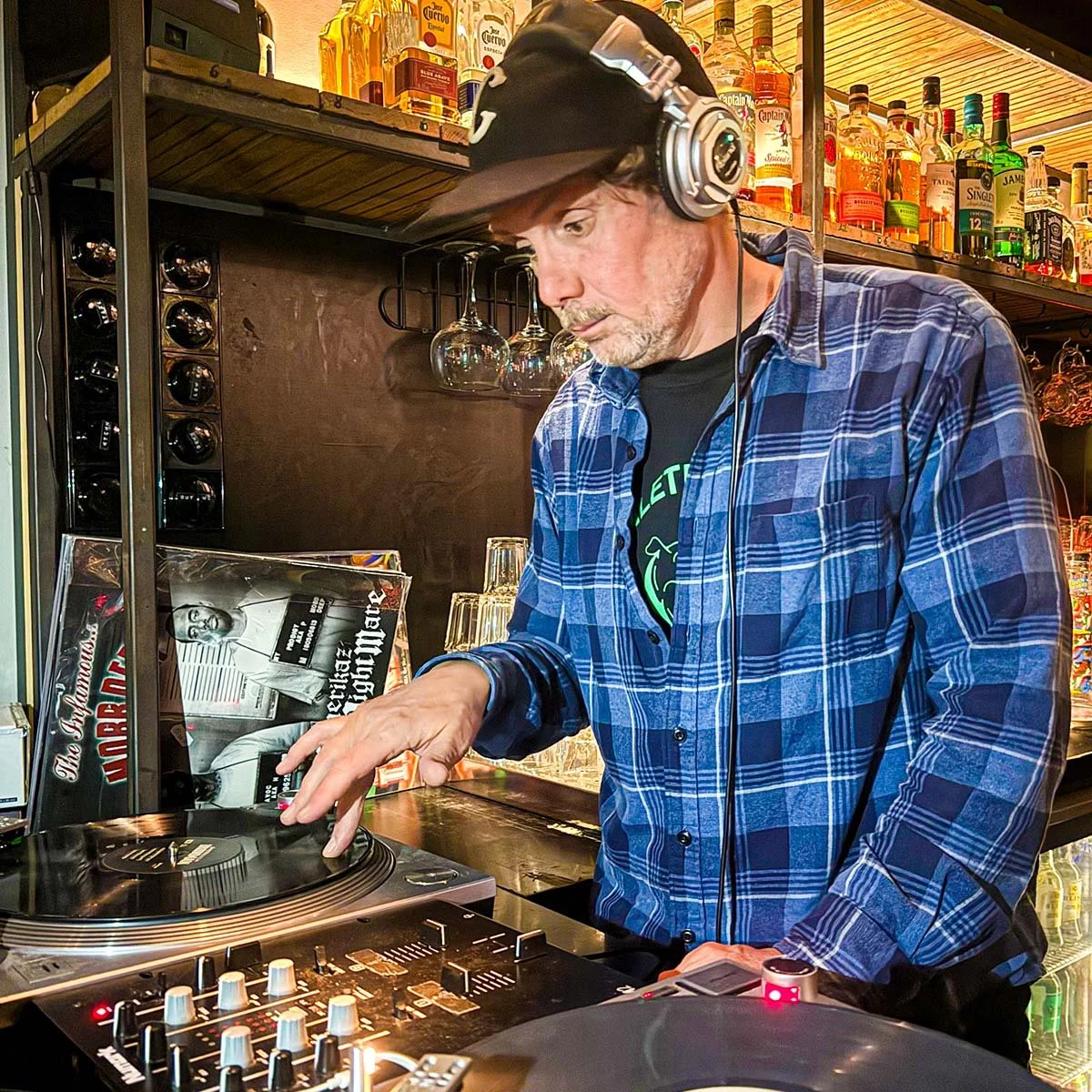 DJ Mouskovich at the turntables playing a guest DJ set at Amsterdam Vinyl Club, a live music community event.