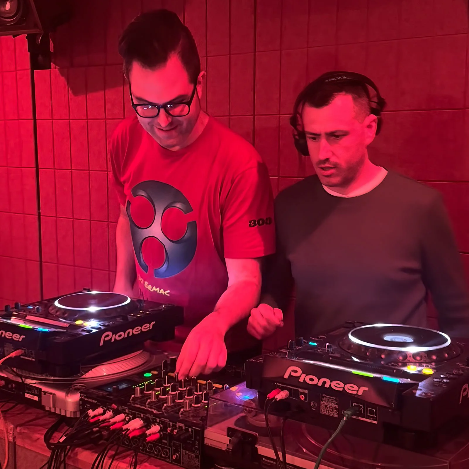 DJ Ermac and DJ Kuver at the turntables playing a guest DJ set at Amsterdam Vinyl Club, a live music community event.