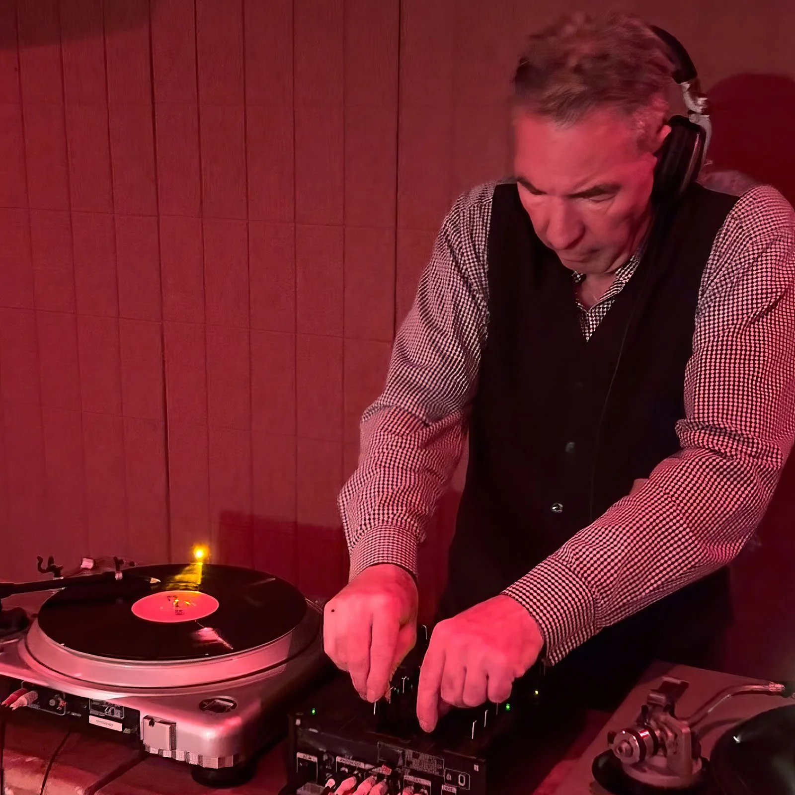DJ Jaimy at the turntables playing a guest DJ set at Amsterdam Vinyl Club, a live music community event.