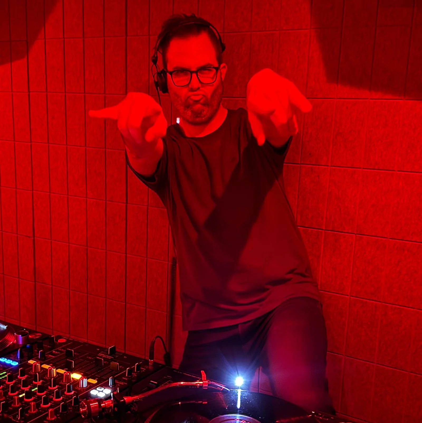 DJ Erman at the turntables playing a guest DJ set at Amsterdam Vinyl Club, a live music community event.