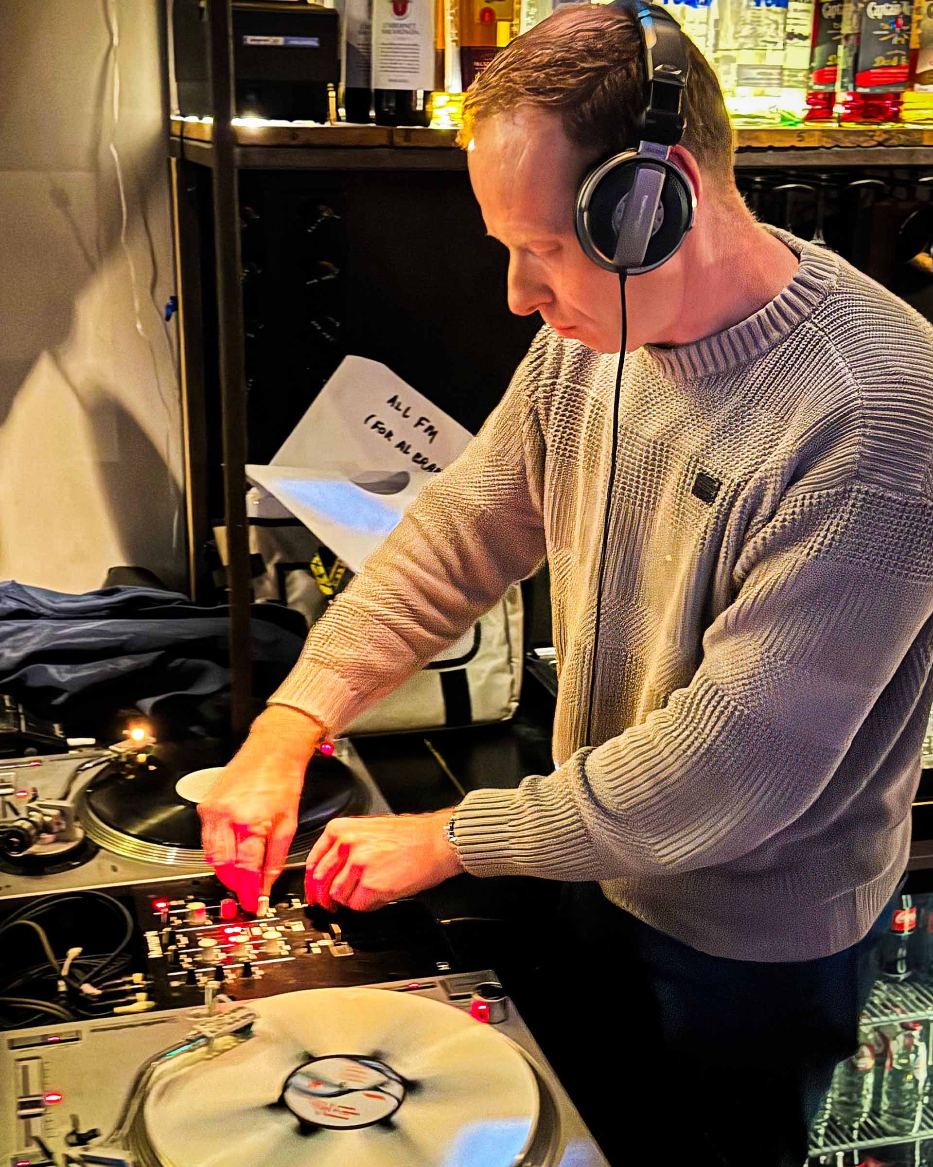 DJ Miro at the turntables playing a guest DJ set at Amsterdam Vinyl Club, a live music community event.