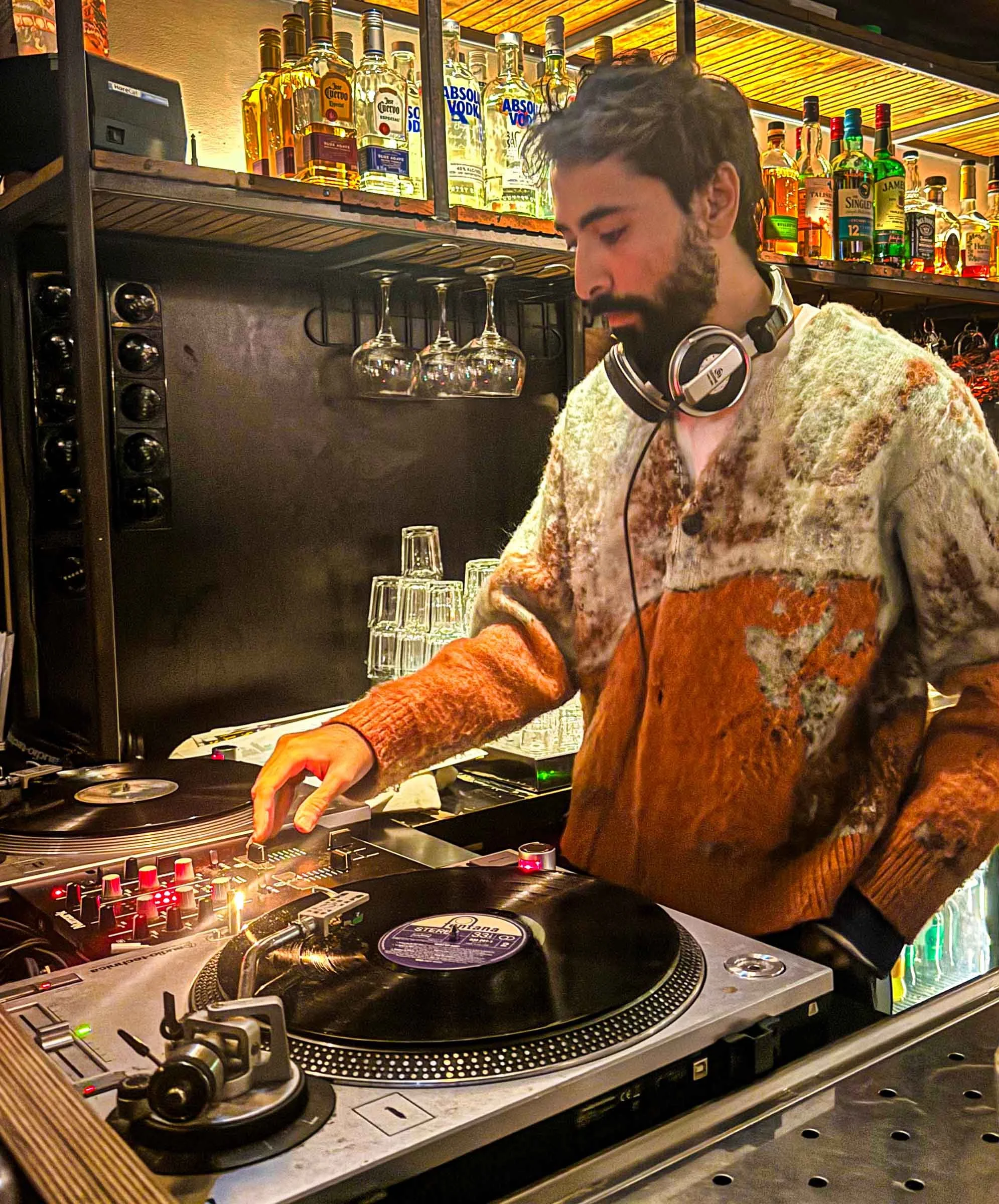Adnan Samman at the turntables playing a guest DJ set at Amsterdam Vinyl Club, a live music community event.
