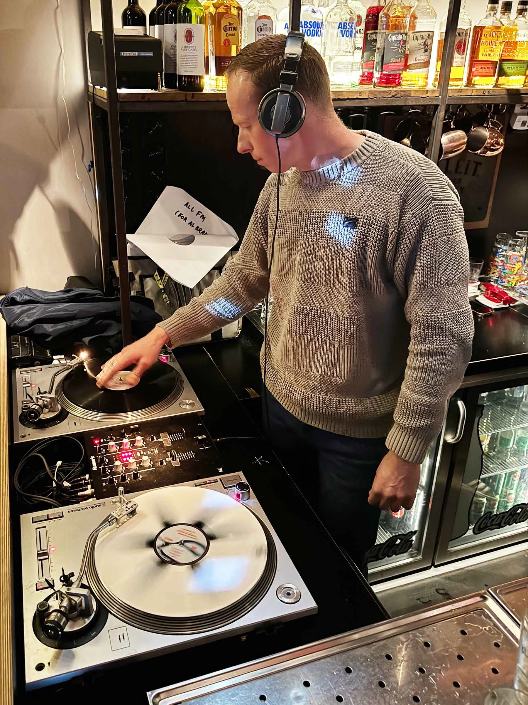 DJ Miro at the turntables playing a guest DJ set at Amsterdam Vinyl Club, a live music community event.