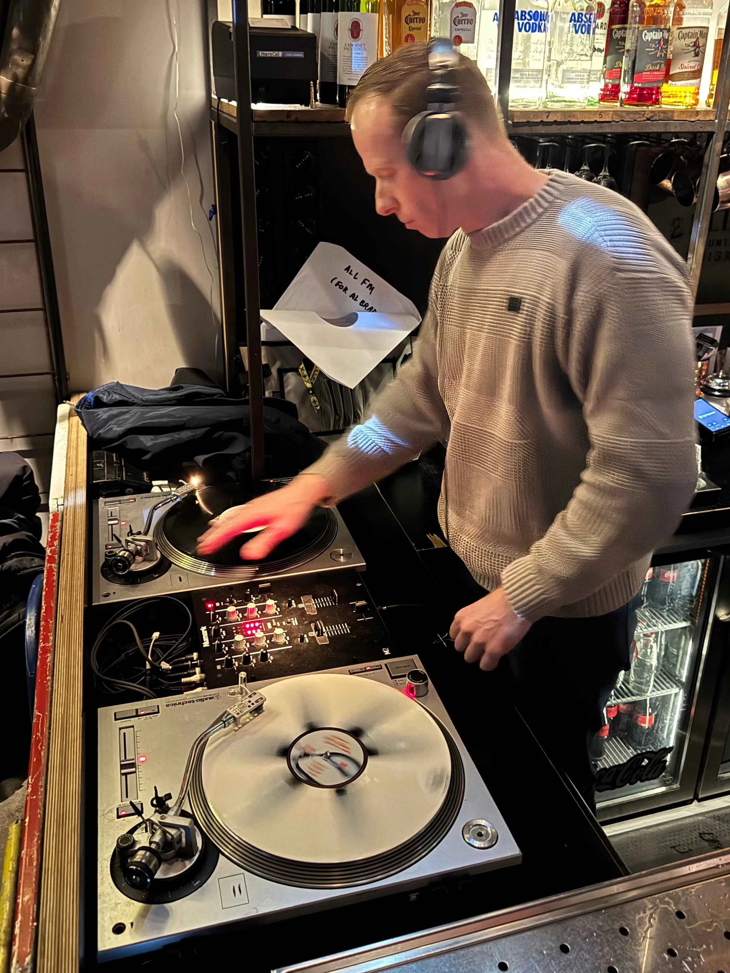 DJ Miro at the turntables playing a guest DJ set at Amsterdam Vinyl Club, a live music community event.