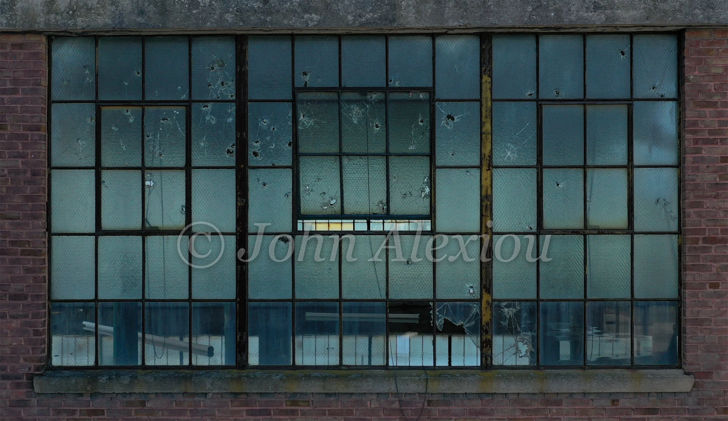 05 · The Grid Holds
Weathered blue-green glass fills a broad window, with light showing through along the bottom.
© John Alexiou · 2019 · Scranton Lace Company