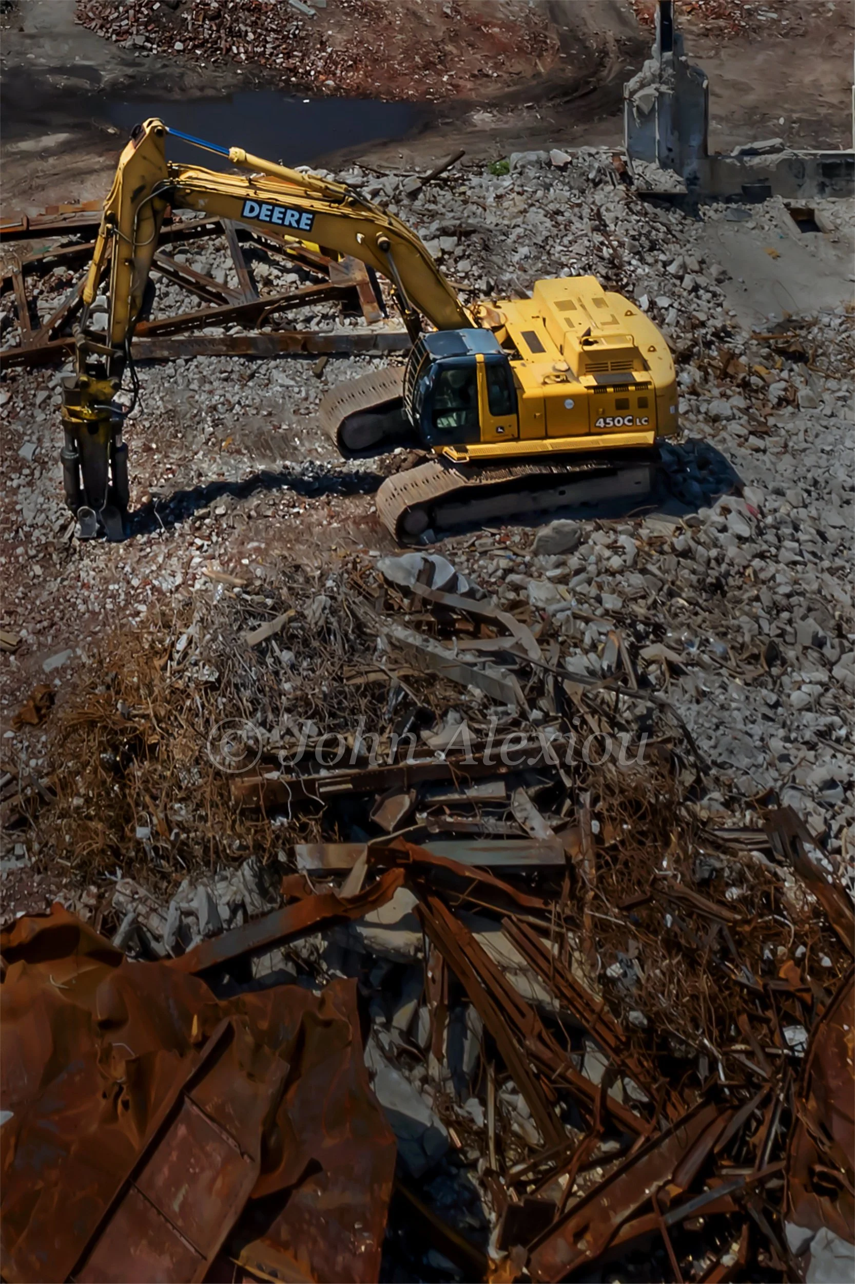 14 · The Landscape Changes Again
A yellow excavator stands among rubble, twisted metal and the remains of the factory.
© John Alexiou · 2019 · Scranton Lace Company