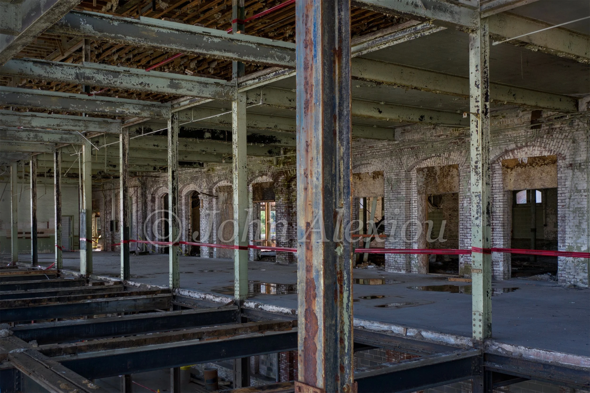 12 · The Rooms Behind the Windows
Rows of worn columns and exposed beams stretch across an opened factory interior.
© John Alexiou · 2019 · Scranton Lace Company