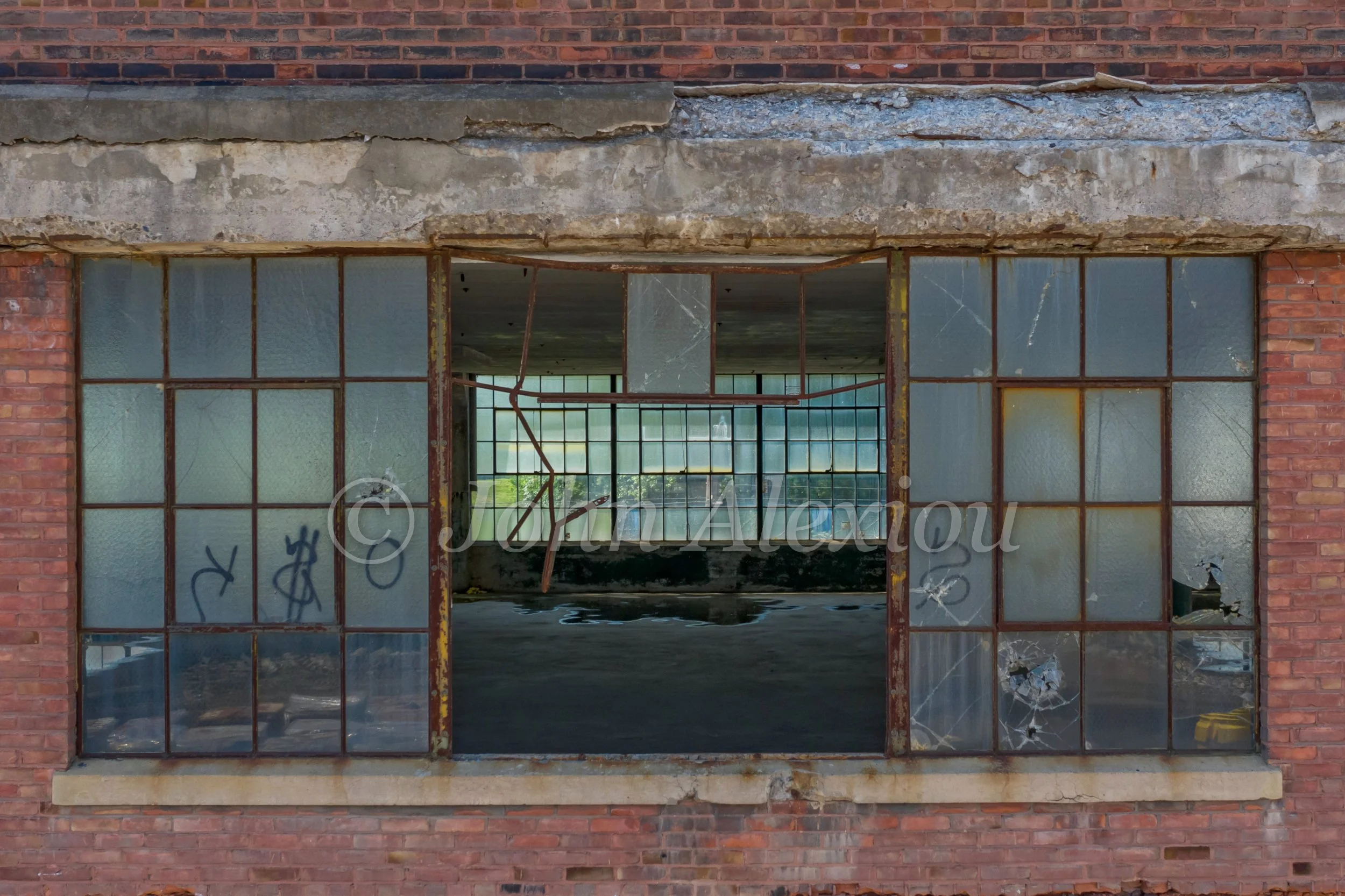 07 · An Opening in the Wall
A wide gap in the factory windows opens onto an empty floor and distant daylight.
© John Alexiou · 2019 · Scranton Lace Company