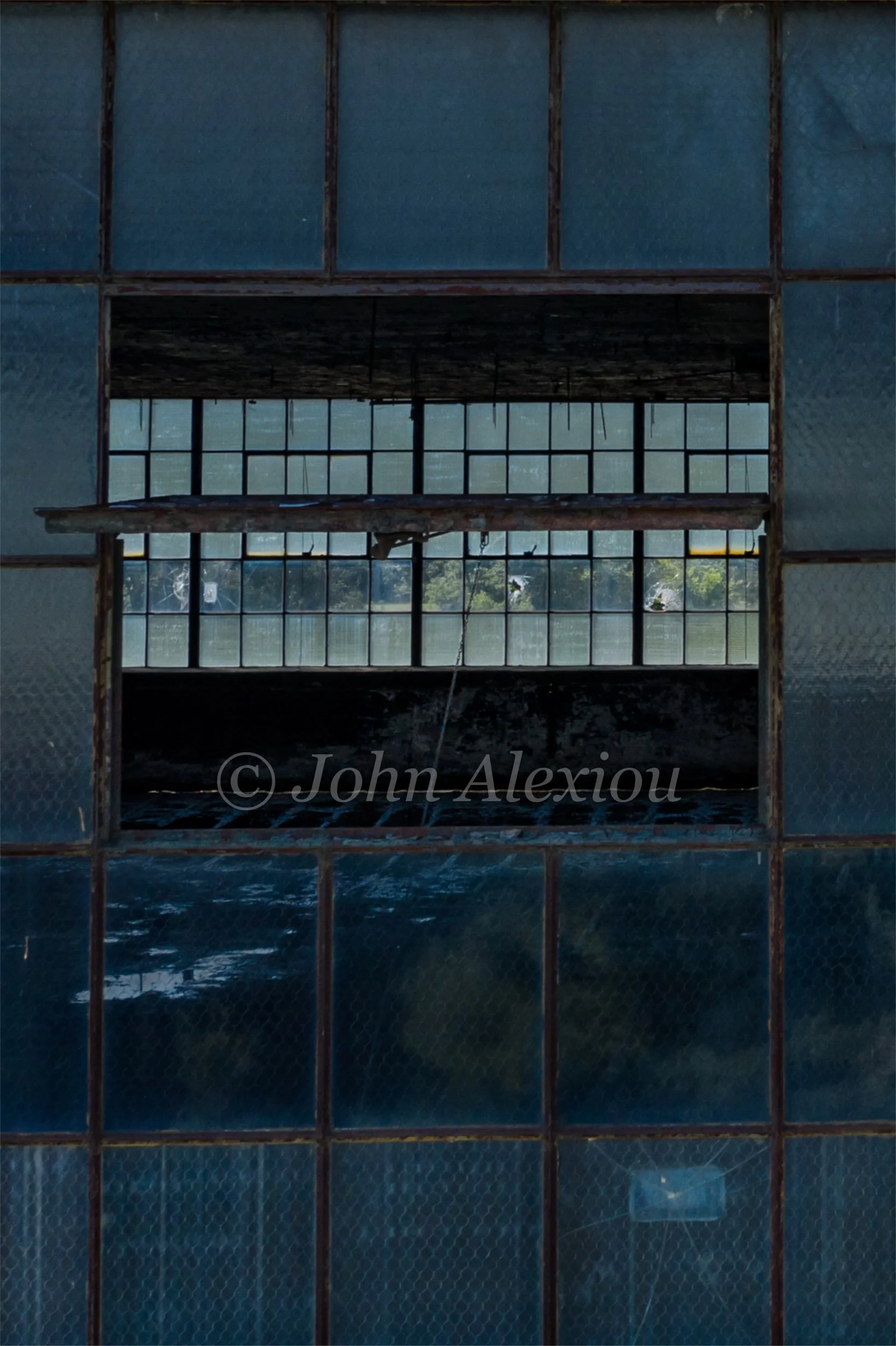 06 · Looking Straight Through
A narrow opening in the dark window grid reveals another wall of glass beyond.
© John Alexiou · 2019 · Scranton Lace Company